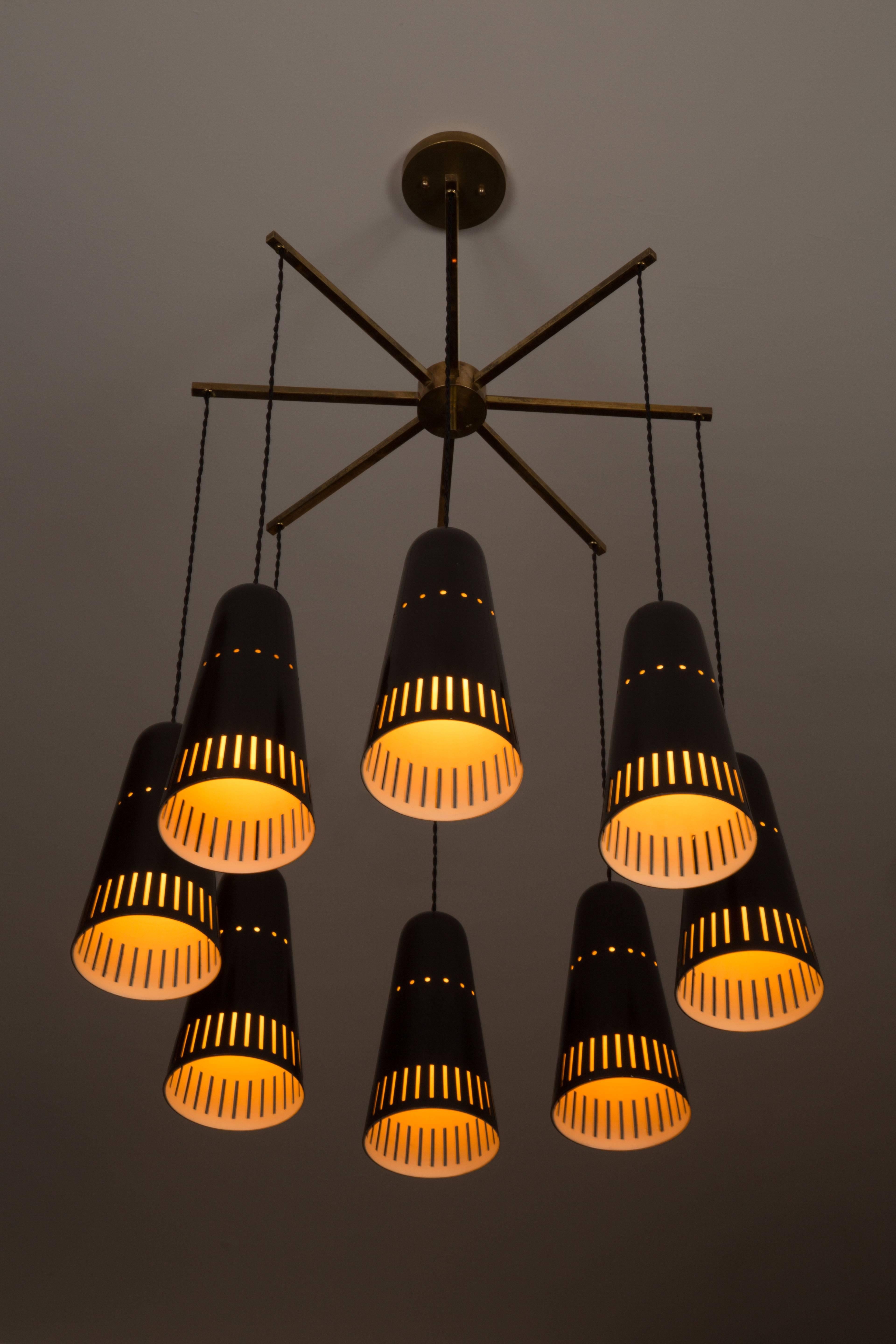 Eight-arm chandelier with French twist cord and perforated shades.