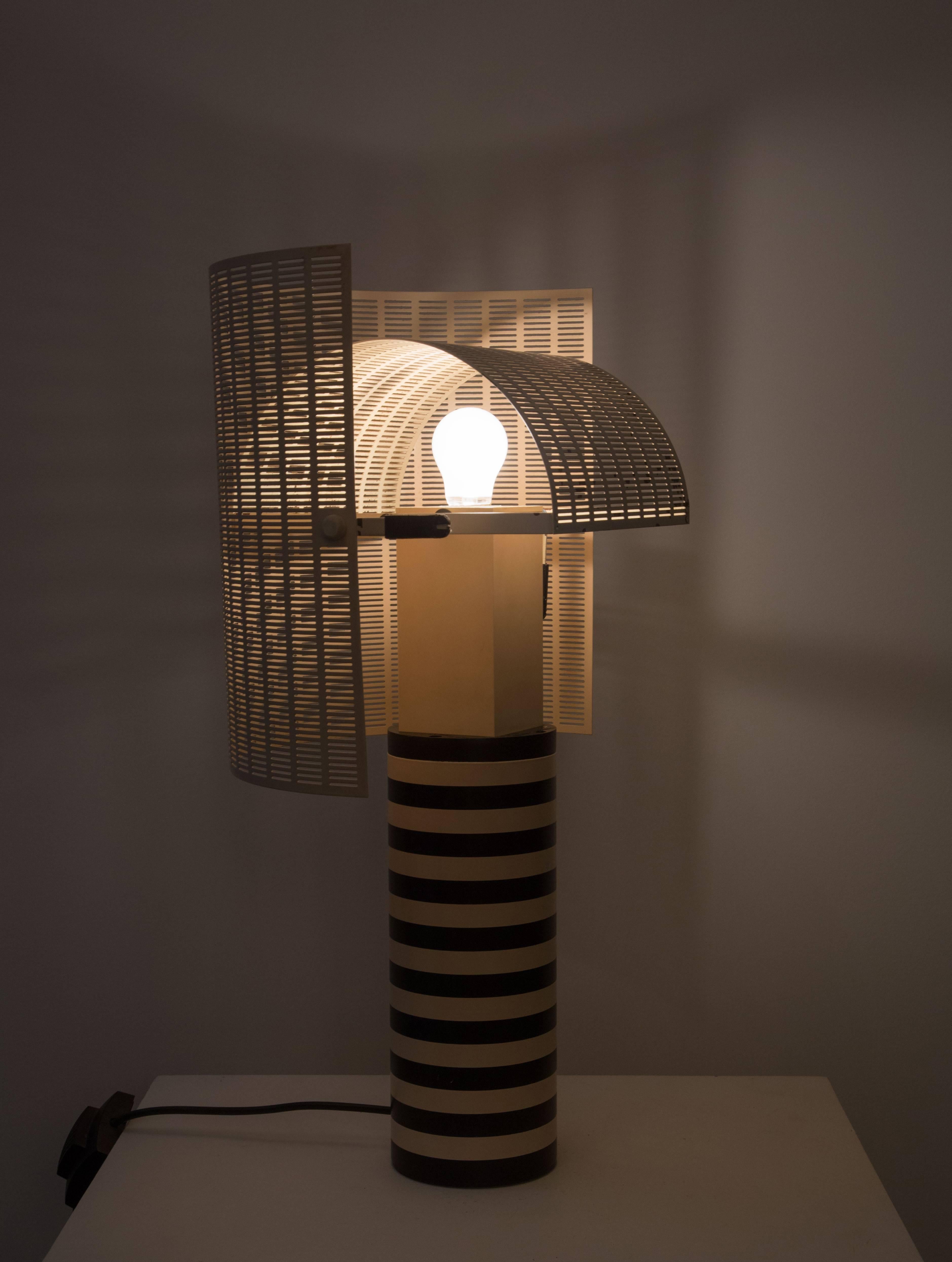 Model 'Shogun Tavolo' table lamp, designed by Mario Botta for Artemide in 1986 in Italy. Both elements of the shade are made from perforated metal diffusers that can be turned independently to shield the light source. Made of enameled aluminum,