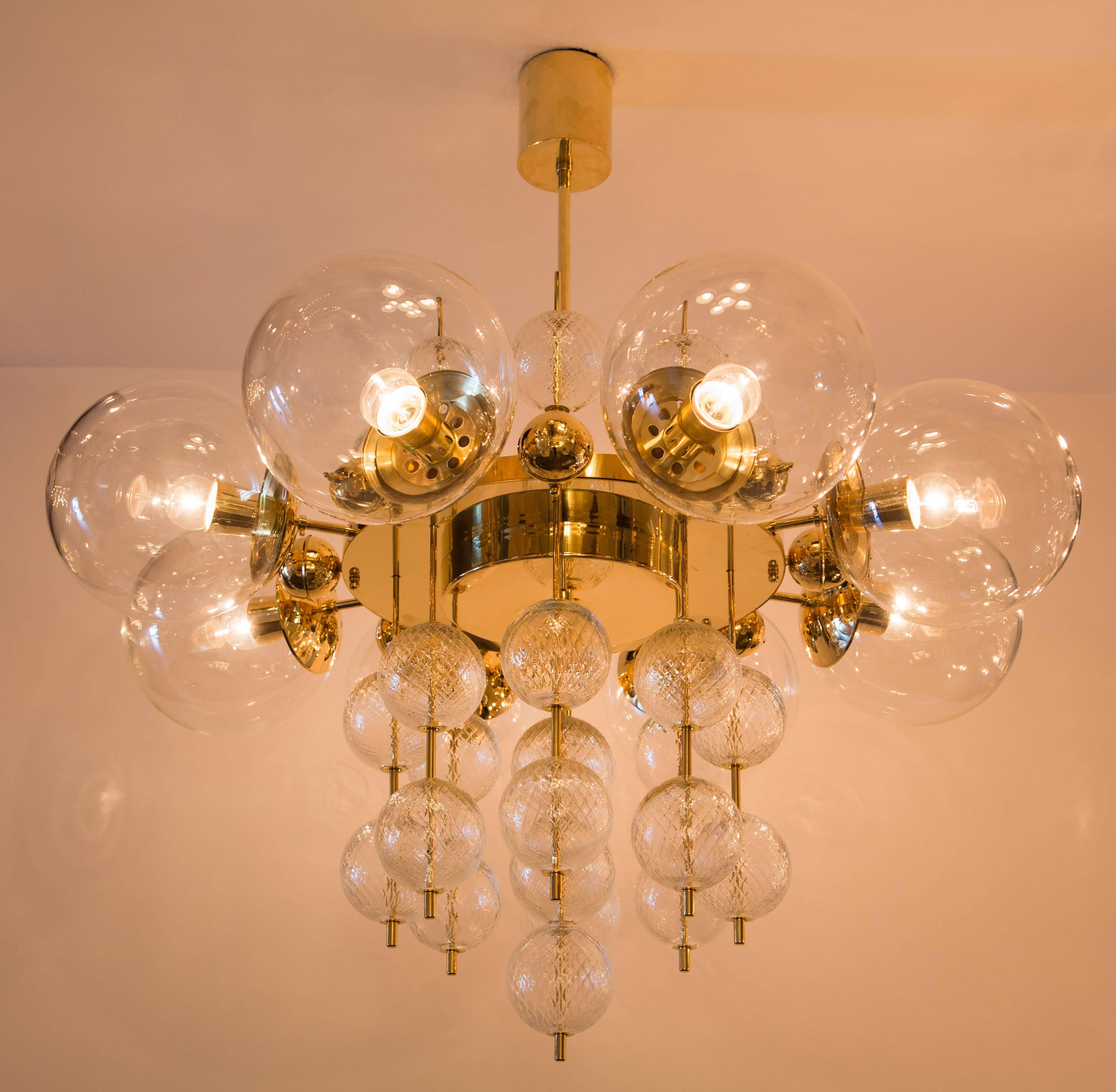 Twenty five globe brass and molded glass chandelier made by Kamenicky Senov in the Czech Republic circa 1960's. Glass is molded with an intricate "quilted" diamond shaped pattern on the smaller globes. 15w maximum European candelabra