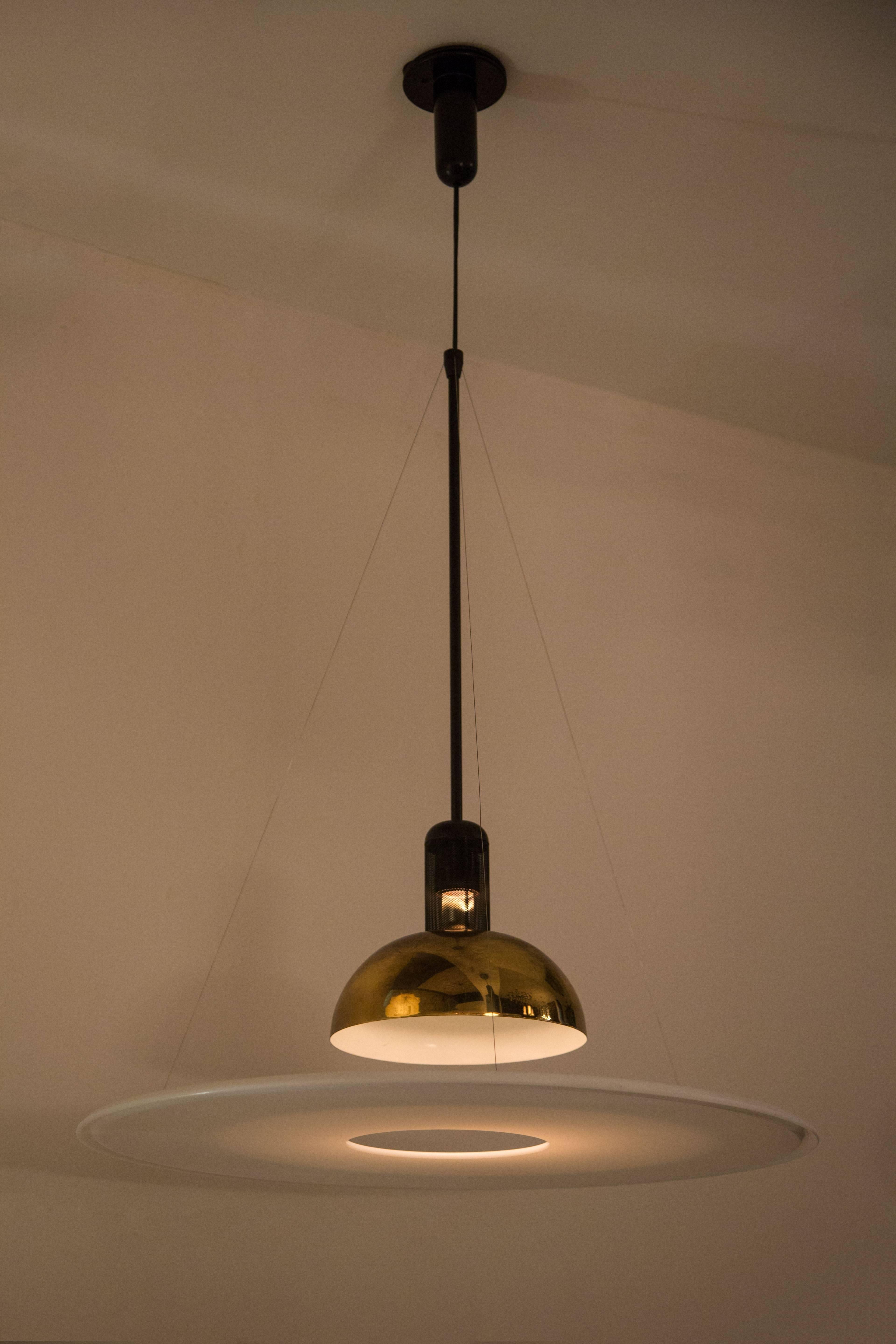 Original pendant light designed in 1978 by Achille Castiglione. The Frisbi provides direct, diffused and reflected illumination. Opal acrylic diffuser is suspended by three fine steel cables. A black metal stem and wire mesh basket assembly secure