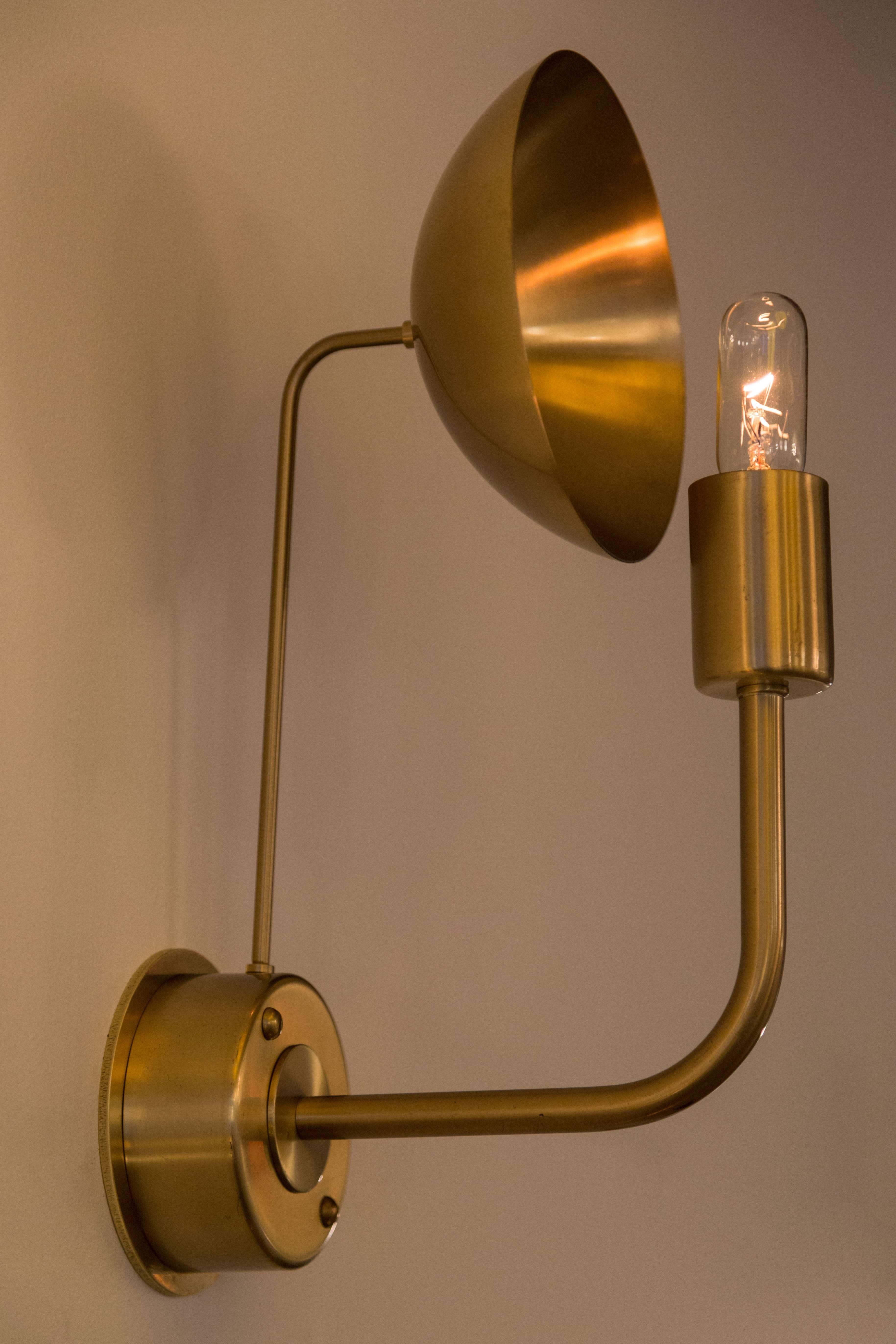 Brass sconces by Hans Agne Jakobsson. Brass reflector illuminated by the base fixture and bulb. Base stem uses a single 25w E14 candelabra bulb. Rewired. Sold individually and priced individually.