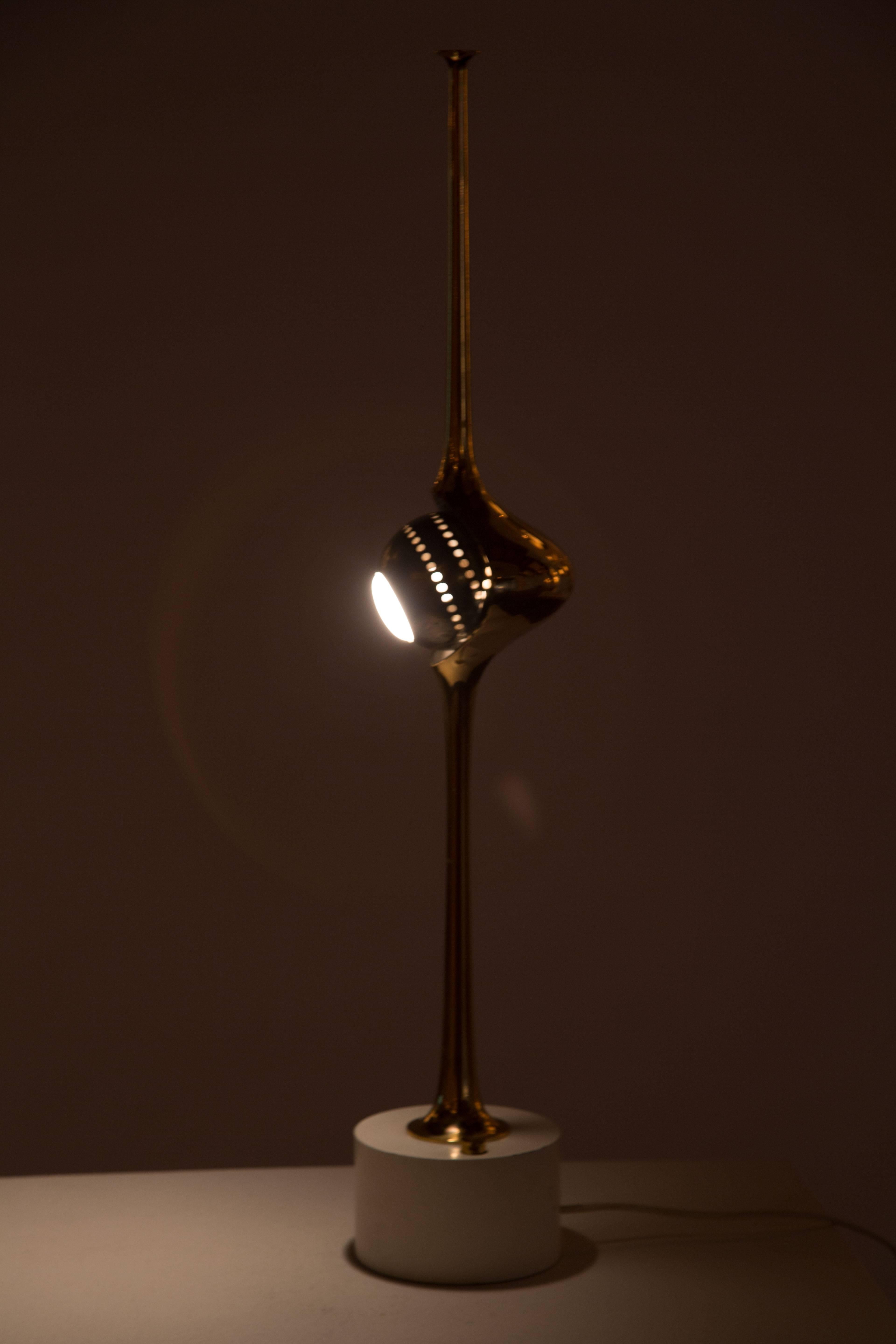 The Cobra table lamp by Angelo Lelli for Arredoluce with fluted cobra shade surrounding a rotating, black nickel eyeball. Lamping is a petite reflector bulb with a candelabra base.
