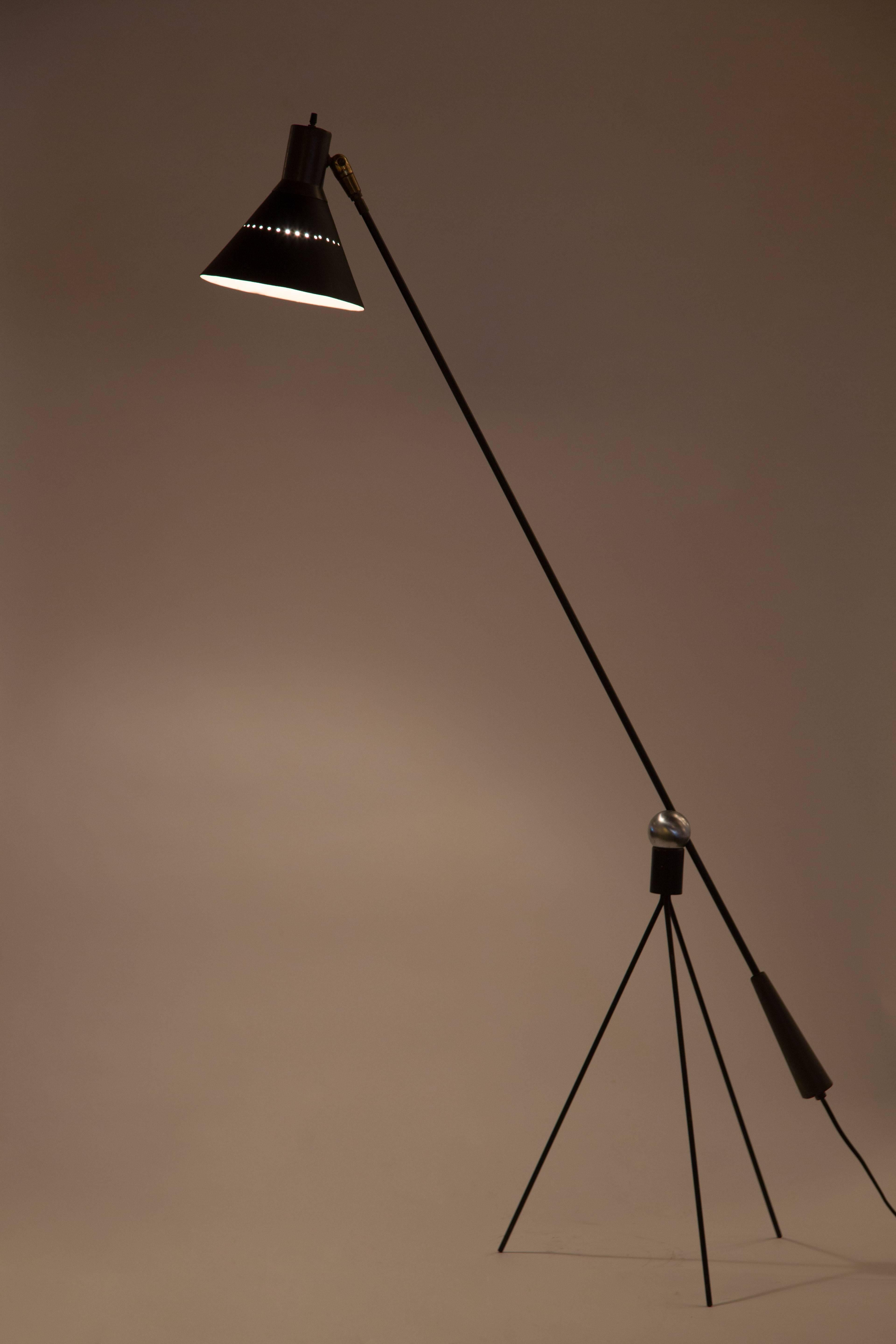 Rare floor lamp by Gilbert Watrous for Heifetz. Floor lamp has an articulating arm which adjust from the metal ball which rest at the top of the tripod base. Original shade with perforations. On/off switch located at the top of the shade. E27 75 W