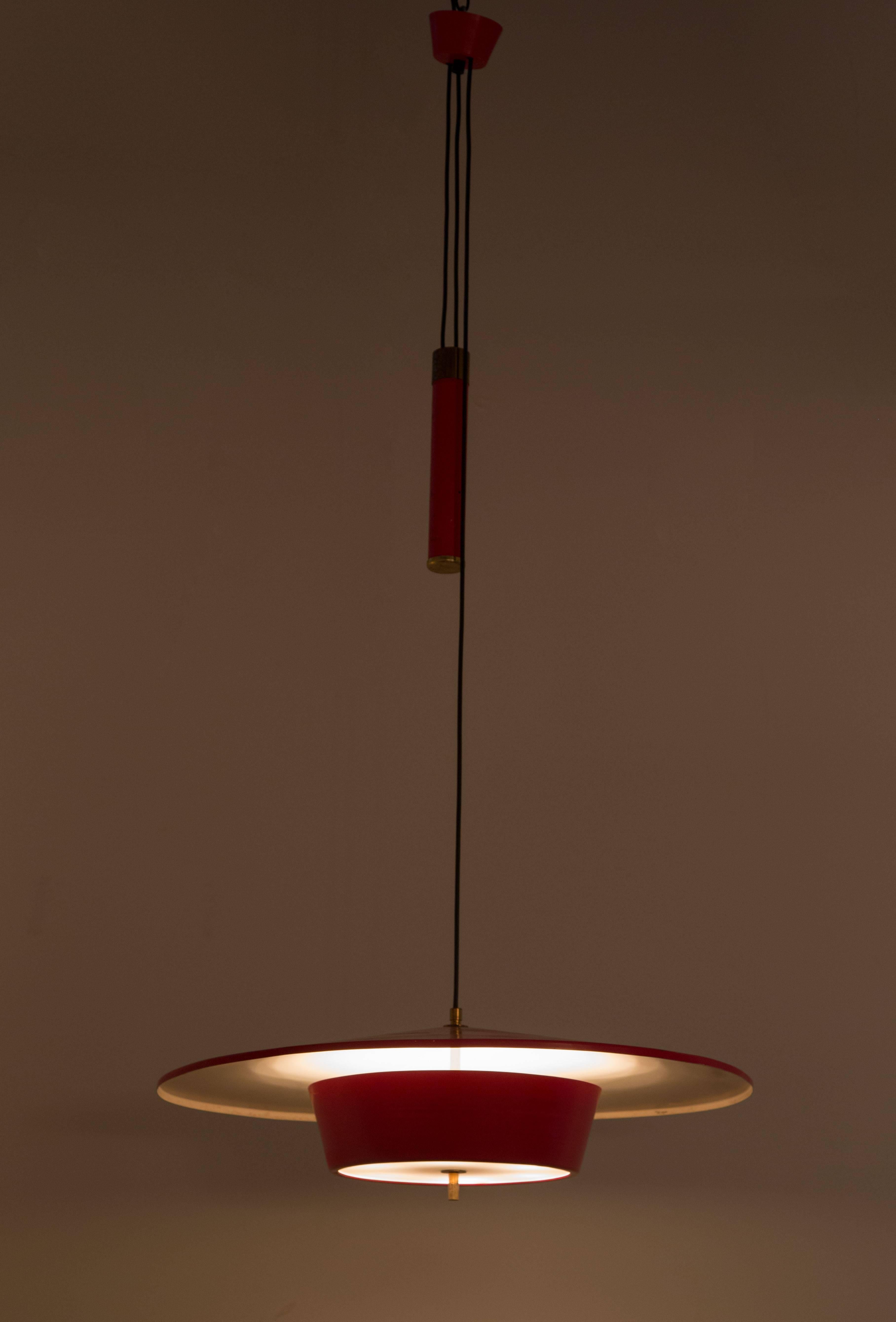 Counterweight pendant by Stilux Milano. Solid metal counterweight with brass accents allows the light to adjust in height. Acrylic diffuser with brass finial. Shades fully restored. E27 75w maximum bulb.