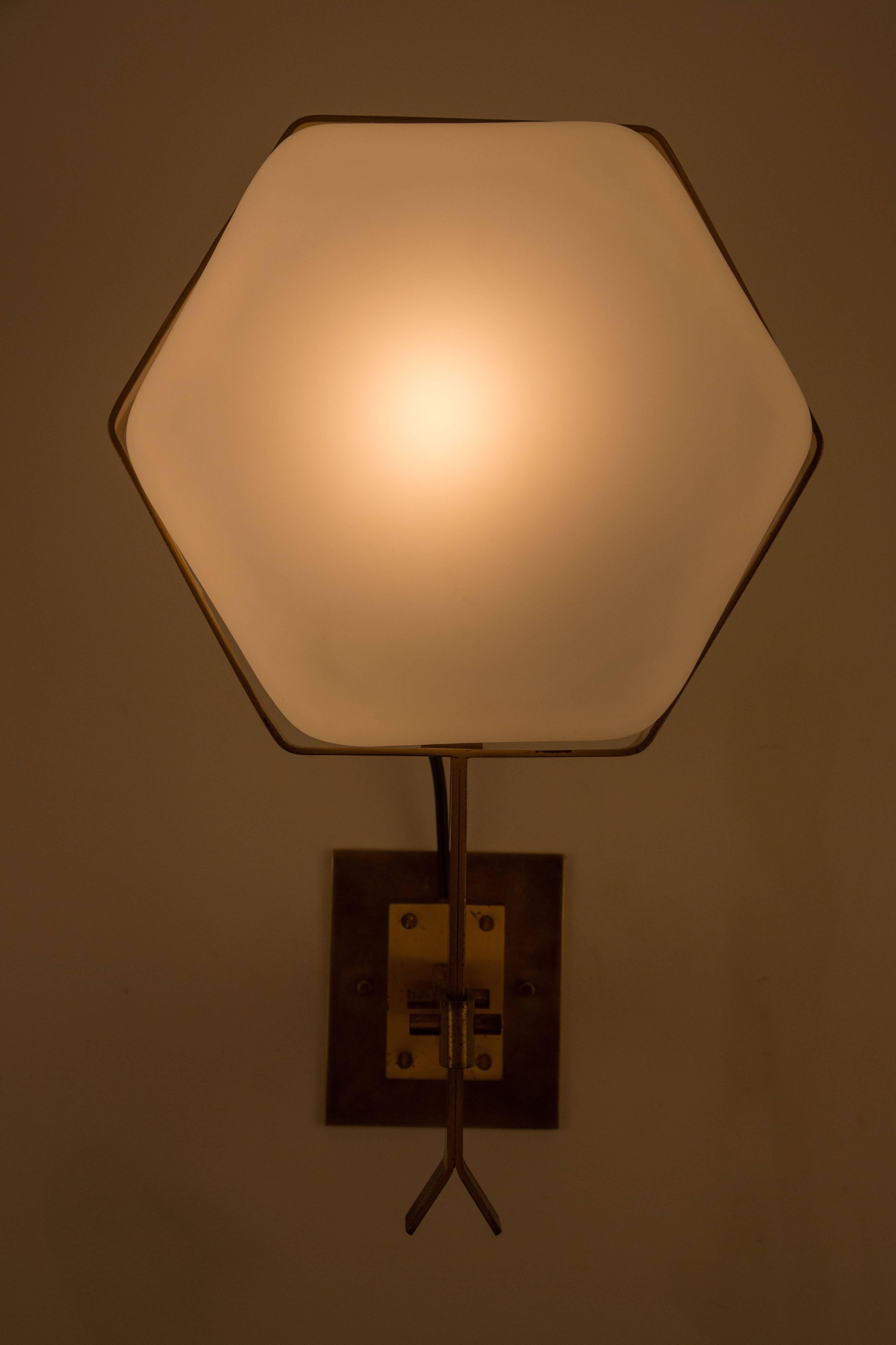 Four brass and satin glass hexagon shaped sconces by Stilnovo. Produced in Italy in the 1950s. Sold in pairs only at $7500 per pair. Each sconces has a brass mechanism in the back that unlocks the glass to change the bulb. E27 75w maximum bulbs.