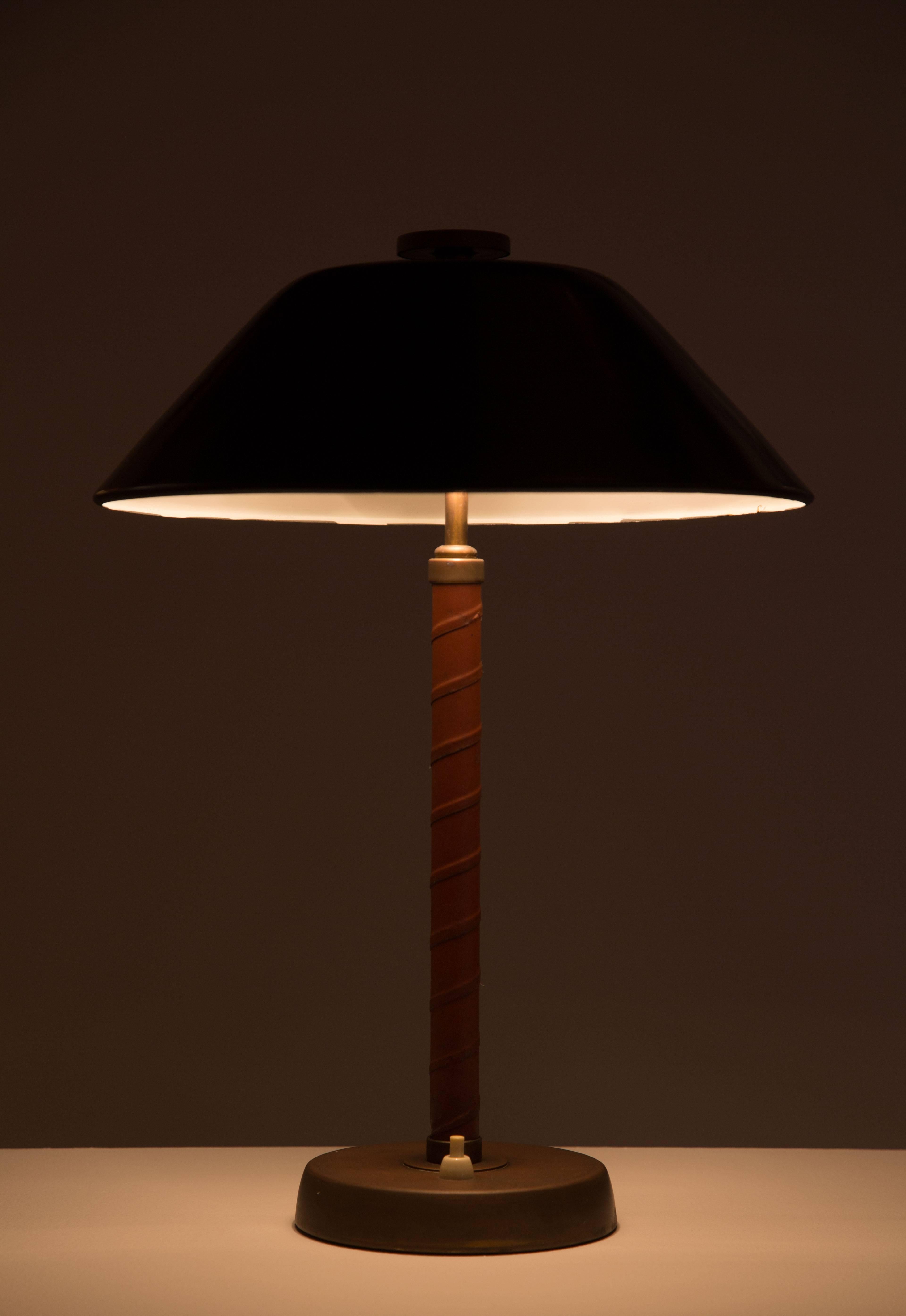 Swedish table lamp made of brass with a leather wrapped stem, designed and made by Einar Bäckström in Malmö, Sweden in the 1940s. Original cord. E27 60 W maximum bulb. Original made in Sweden stamp on the bottom.