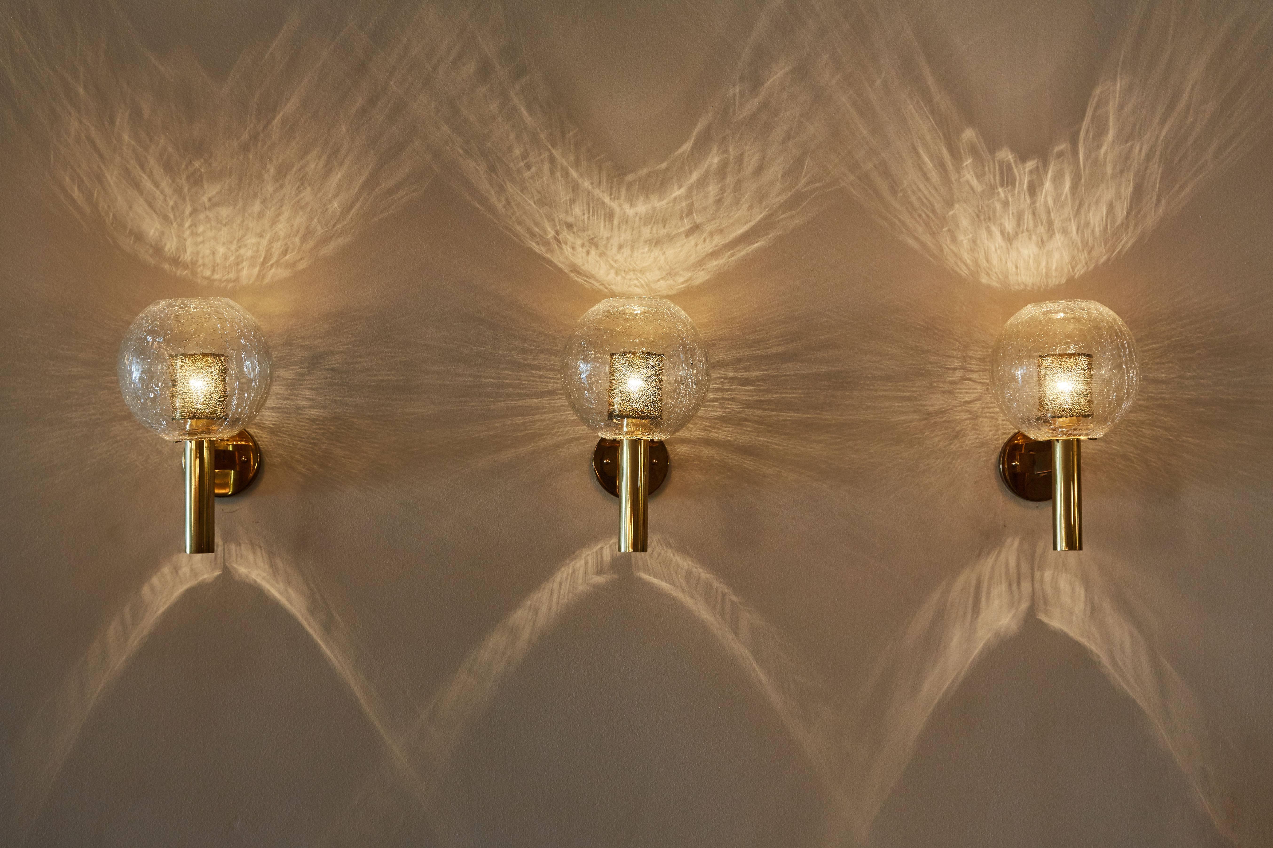 Three crackled glass and brass sconces designed by Aredoluce. Perforated brass diffuser and brass base. Rewired for US, J boxes. Each sconce takes an E27 60W maximum bulb. Priced individually. Retains original Aredoluce label. 