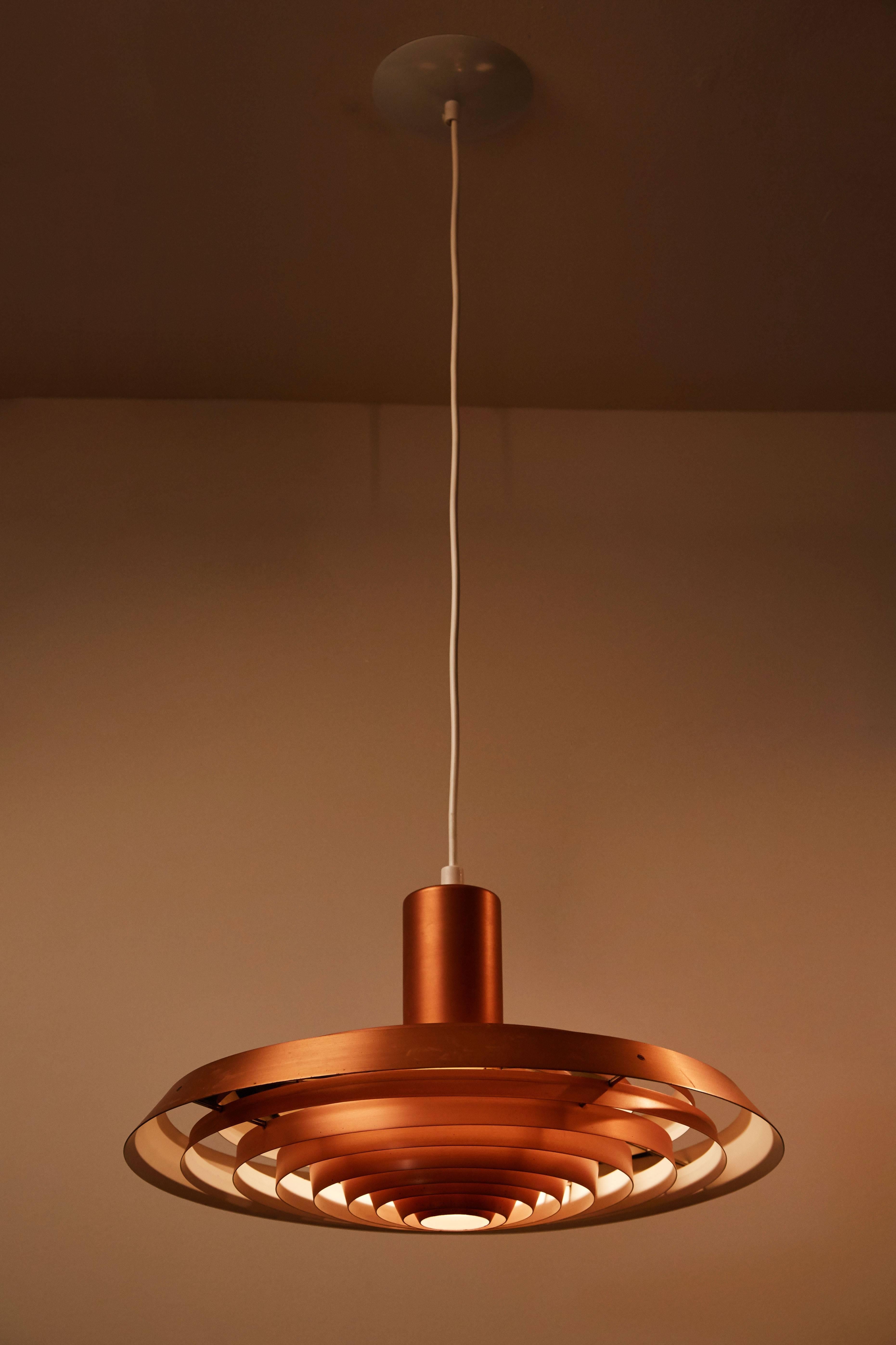Tiered copper hanging fixture designed by Poul Henningsen for Louis Poulsen, circa 1958 for the Langelinie Pavilion in Copenhagen. Takes one E27 100w maximum bulb. Original canopy and cord. Wired for US junction boxes. Two available, priced