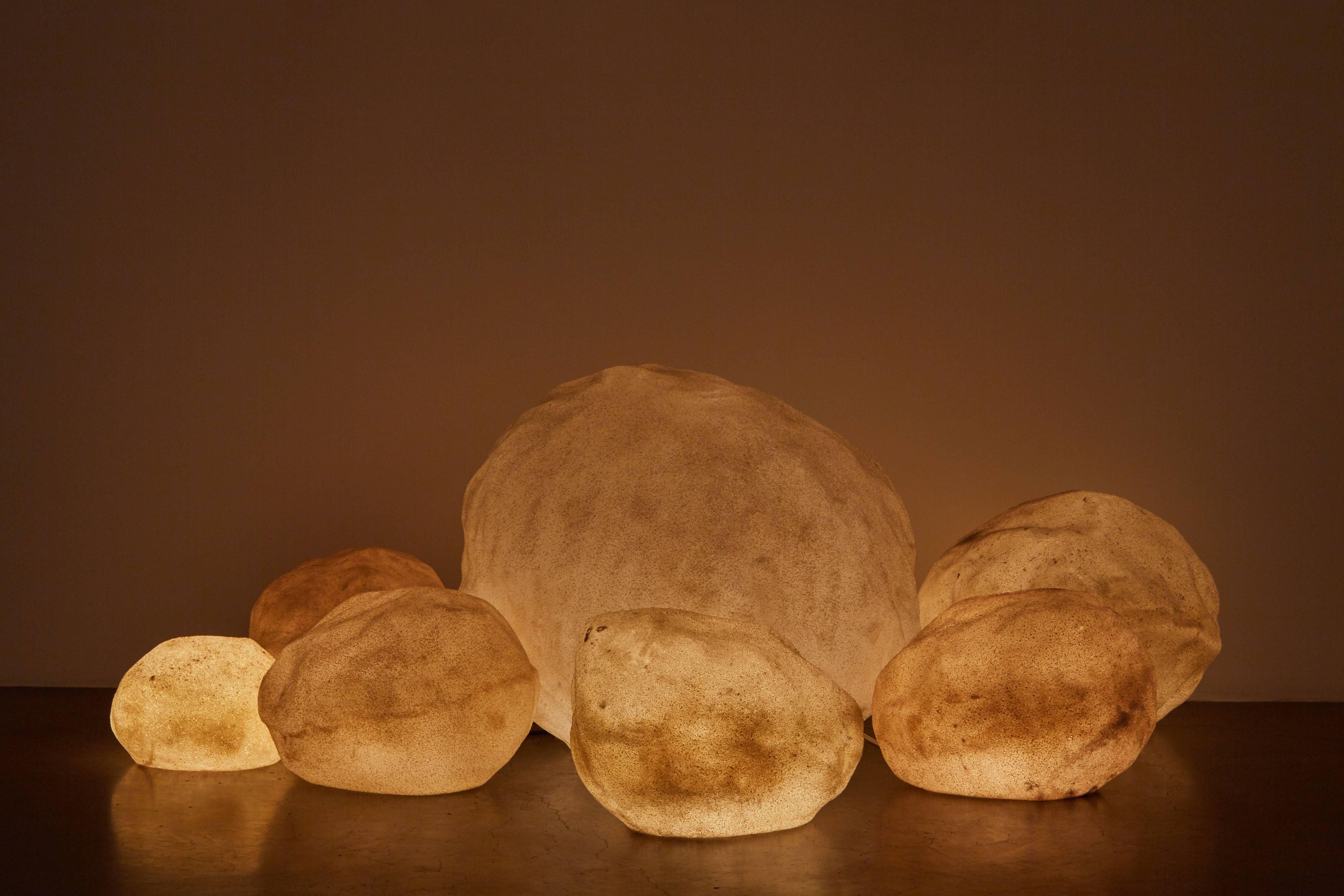 Set of seven hand cast fiberglass rocks. Sold in various sizes as seen as a set or individually. Contact dealer for pricing. Original wiring. Each light takes an E27 40w maximum bulb. Dimensions displayed are for largest rock.