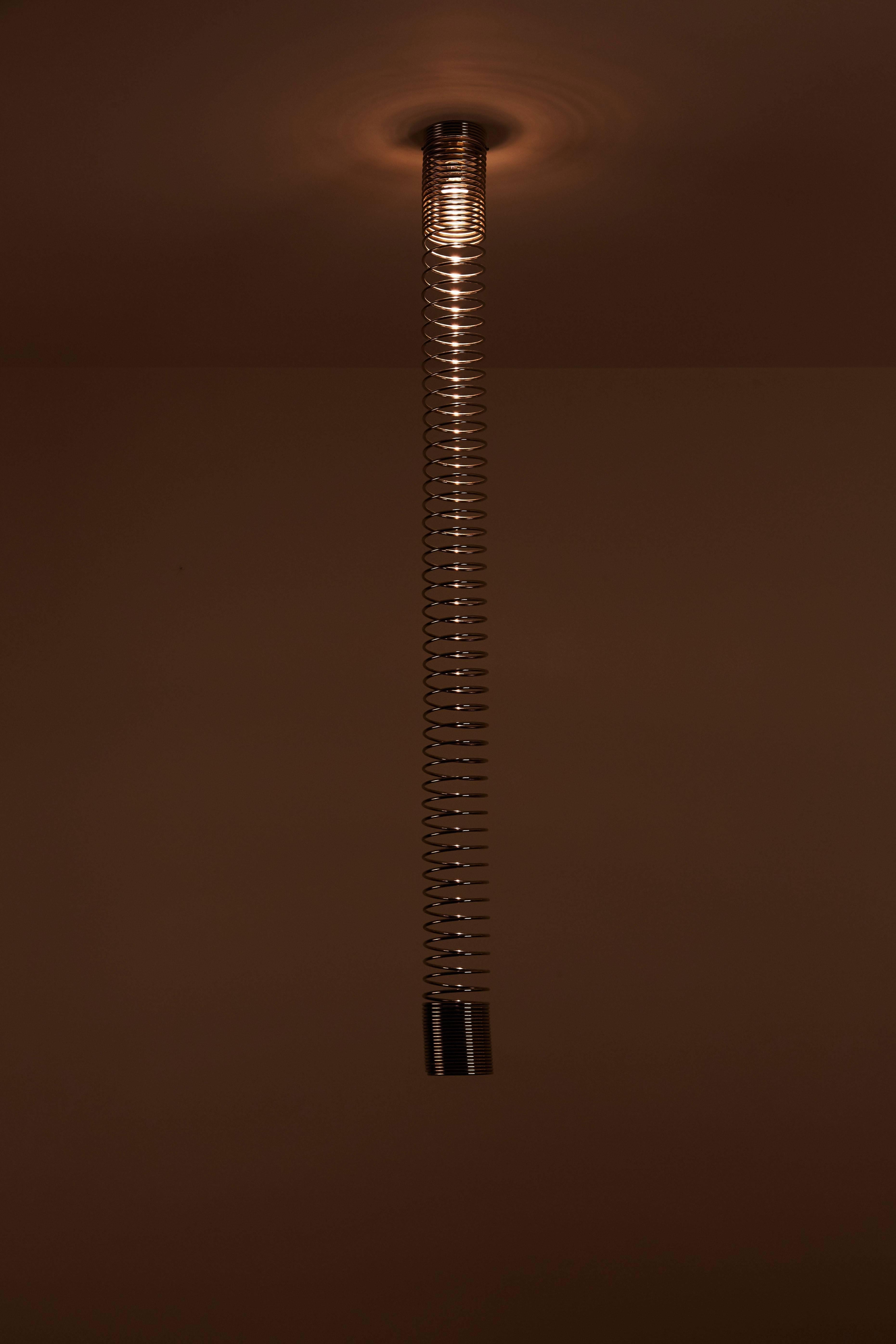 Chromed steel spiral pendants by Angelo Mangiarotti. Each light has a single E27 socket type, adapted for US standards. Recommended 40-60w max or LED equivalent.

See listing image for sizes and inquire with Rewire on availability upon purchasing.
