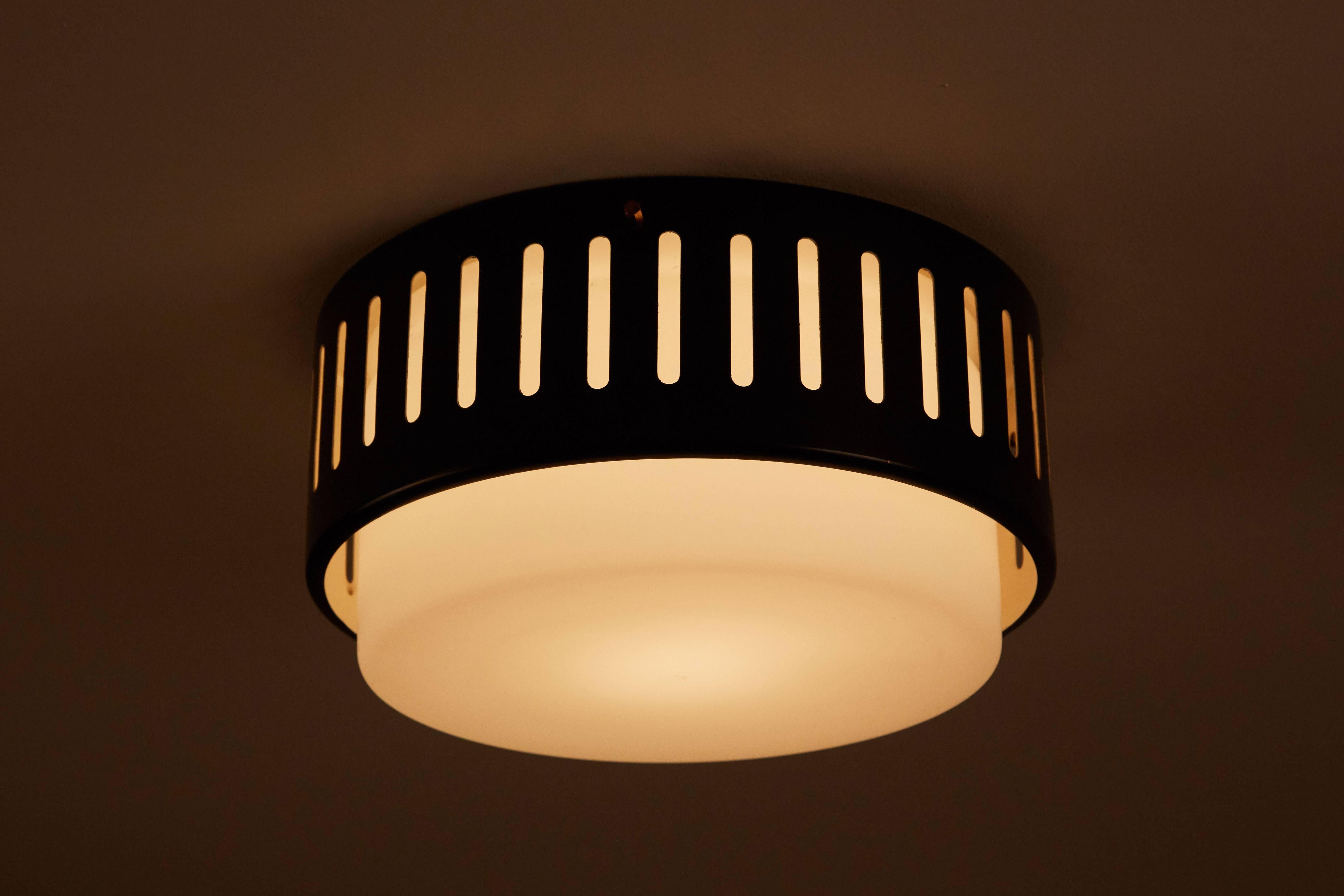 Flush mount ceiling light manufactured by Stilnovo in Italy, circa 1950s. Enameled, perforated metal with brushed satin glass diffuser. Retains original Stilnovo stamp. Wired for US junction boxes. Takes one E27 100w maximum bulb.