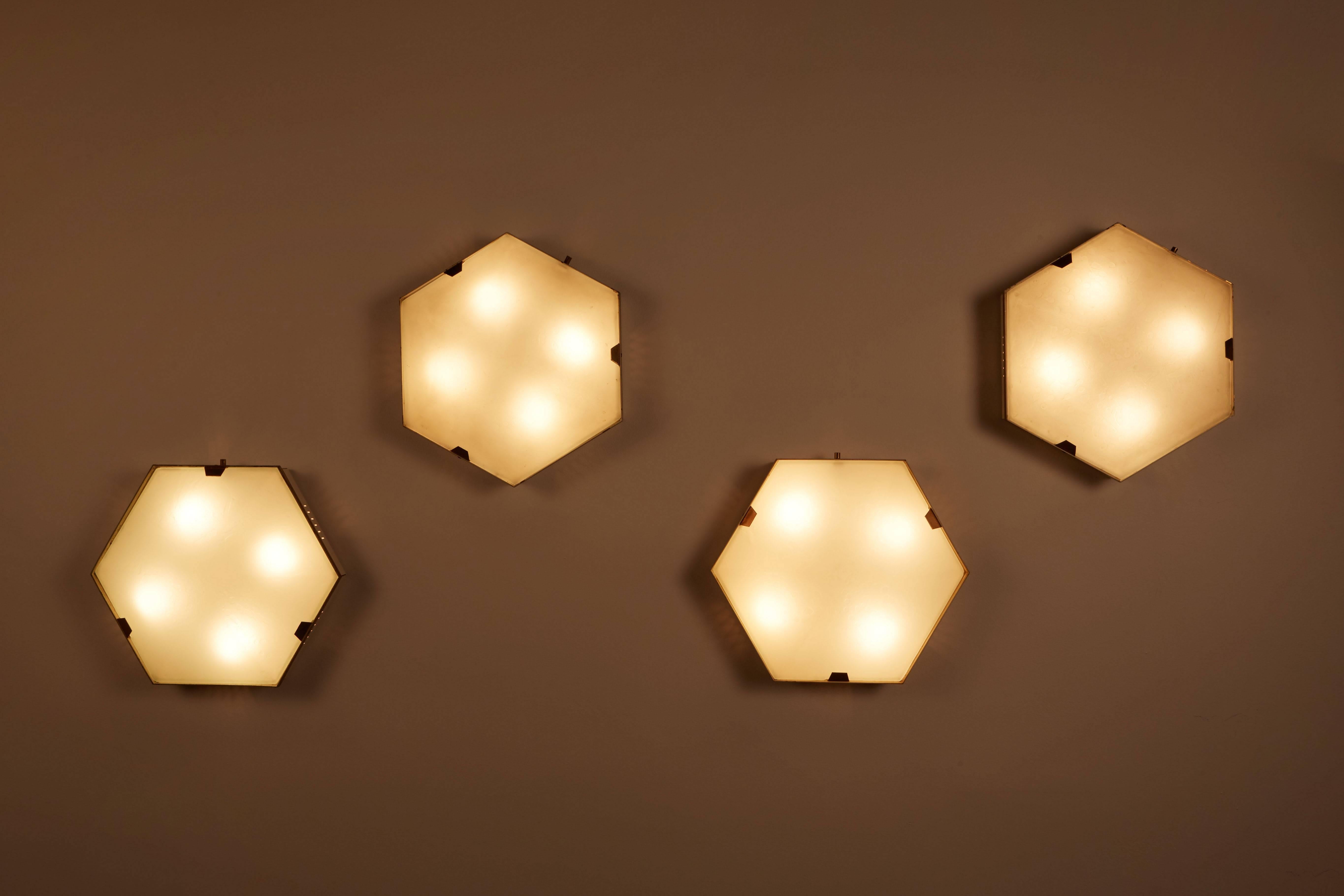 Single hexagonal ceiling/wall lights manufactured by Stilnovo in Italy, circa 1950s. Brass, painted aluminum and textured glass. Sold and priced individually. Wired for US junction boxes. Retains original manufacturers label. Sconce takes one E27