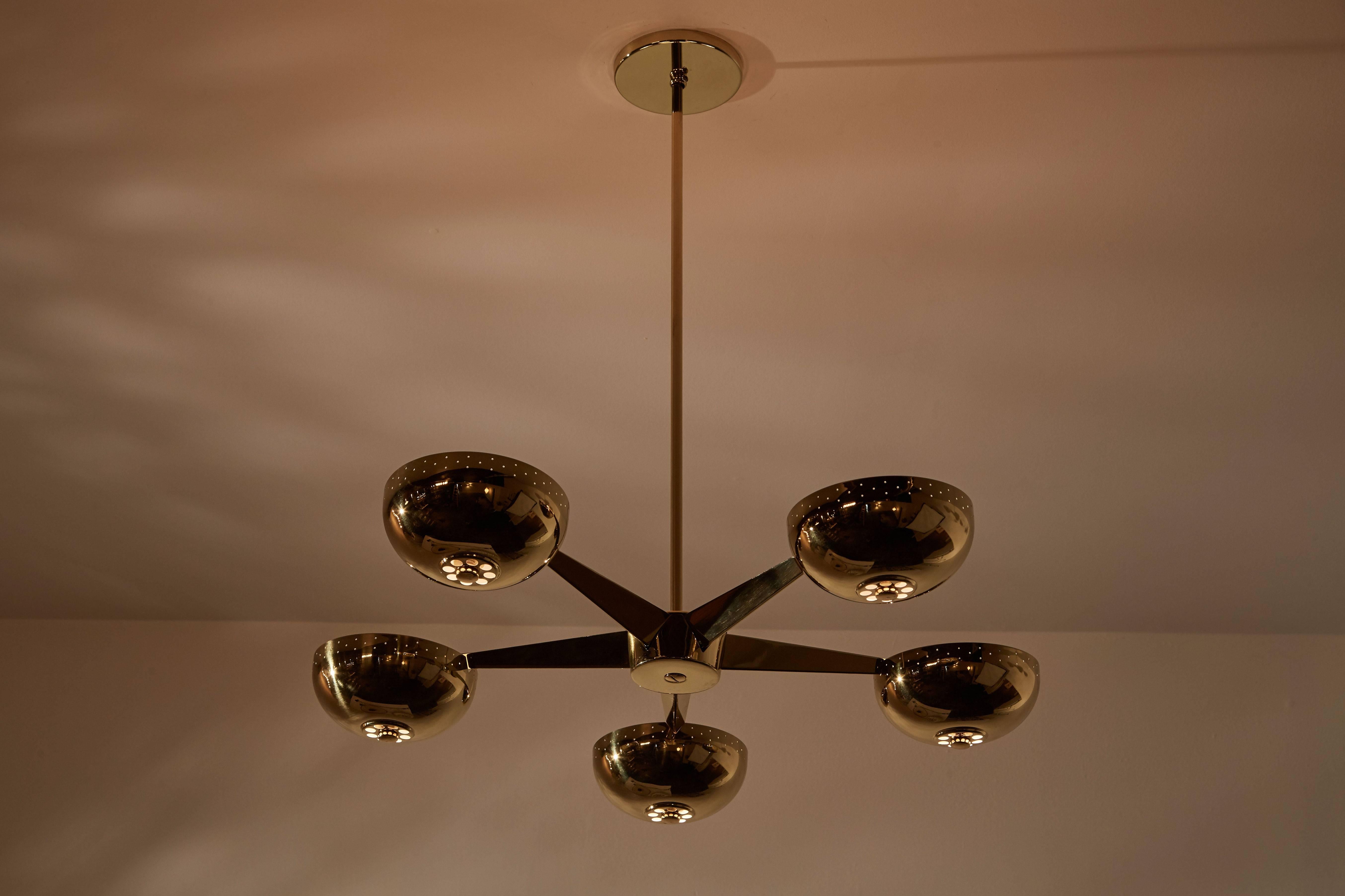 Five-arm brass-plated chandelier in the style of Lightolier in the US, circa 1950s. Perforations to shades. Maintains original manufacturers label. Rewired. Provides uplight. Takes five 100w maximum E26 bulbs.