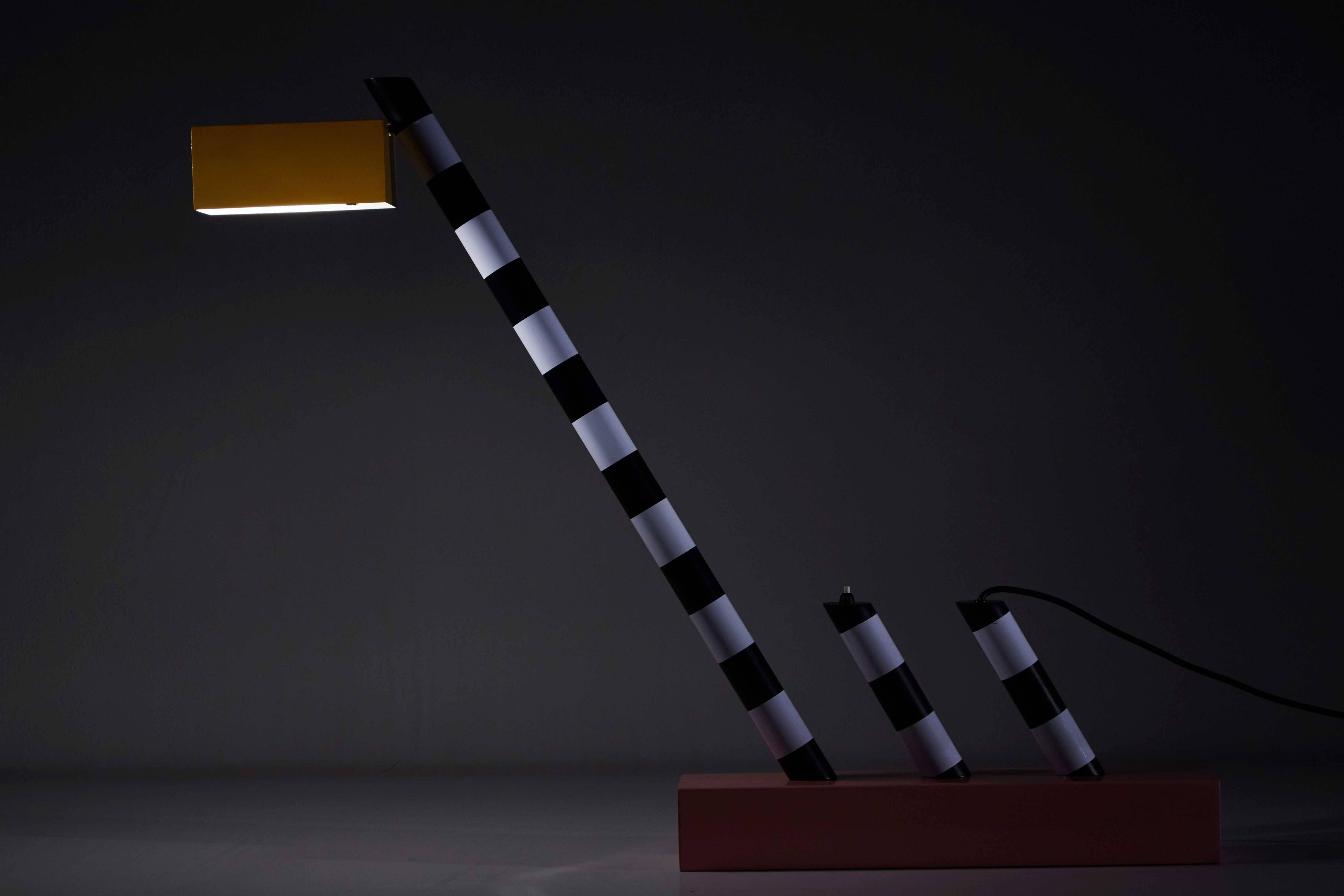 Original oceanic table lamp designed by Michele De Lucchi for Memphis Group in Italy, 1981. Tubular painted metal, polychromatic paint. Retains original manufacturer's stamp to base. Original cord. Takes one E27 100w maximum bulb.
 
