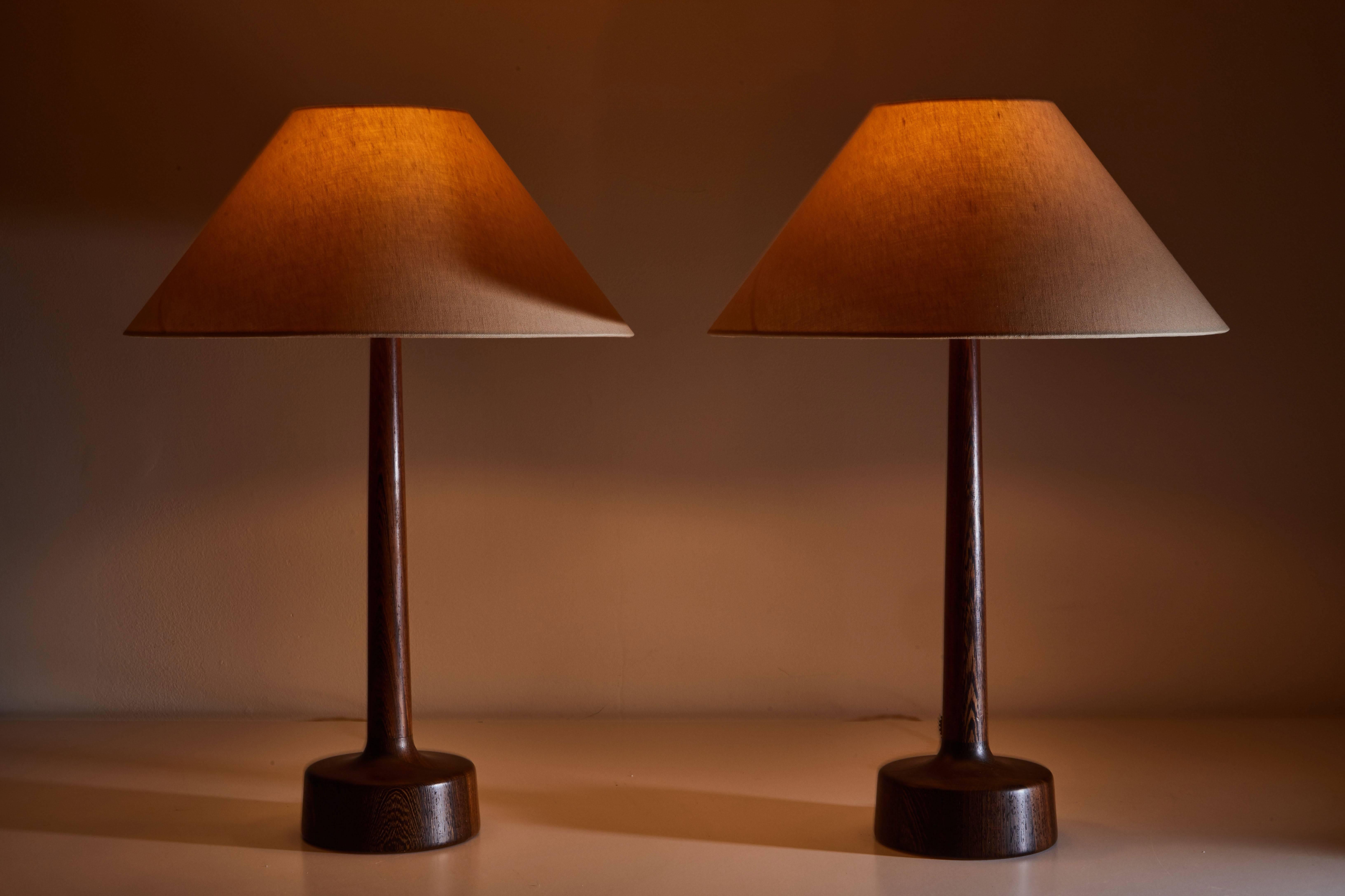 Pair of wengé wood table lamps made in Denmark, circa 1960s. Comes with custom linen shades. Rewired with French twist silk cord. Each Lamp takes one E27 75w maximum bulb.