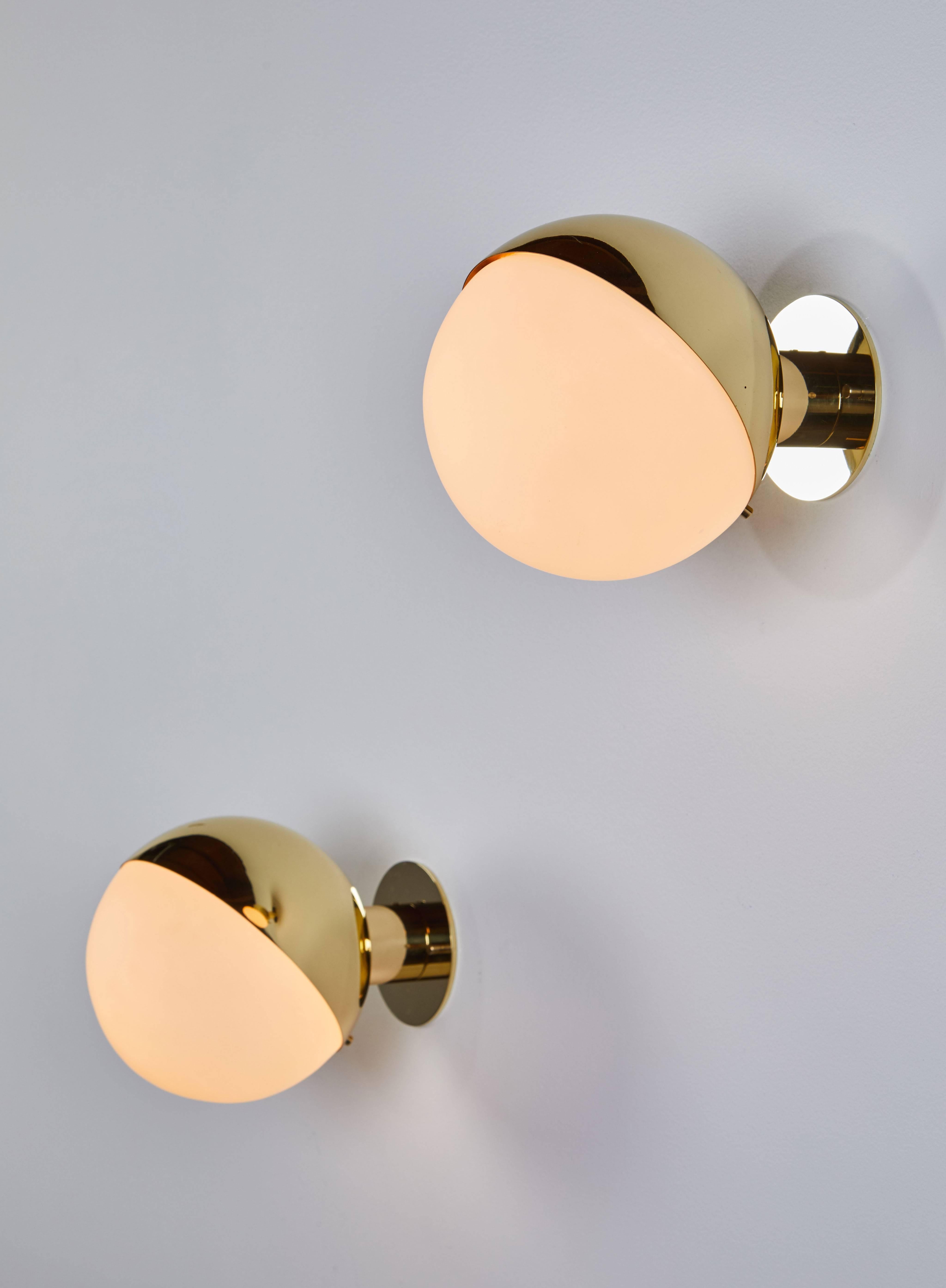 Pair of brass and opaline glass sconces manufactured by Stilnovo in Italy circa 1950's. Wired for US junction boxes. Custom backplates.  Each sconce takes one E27 75w maximum bulb