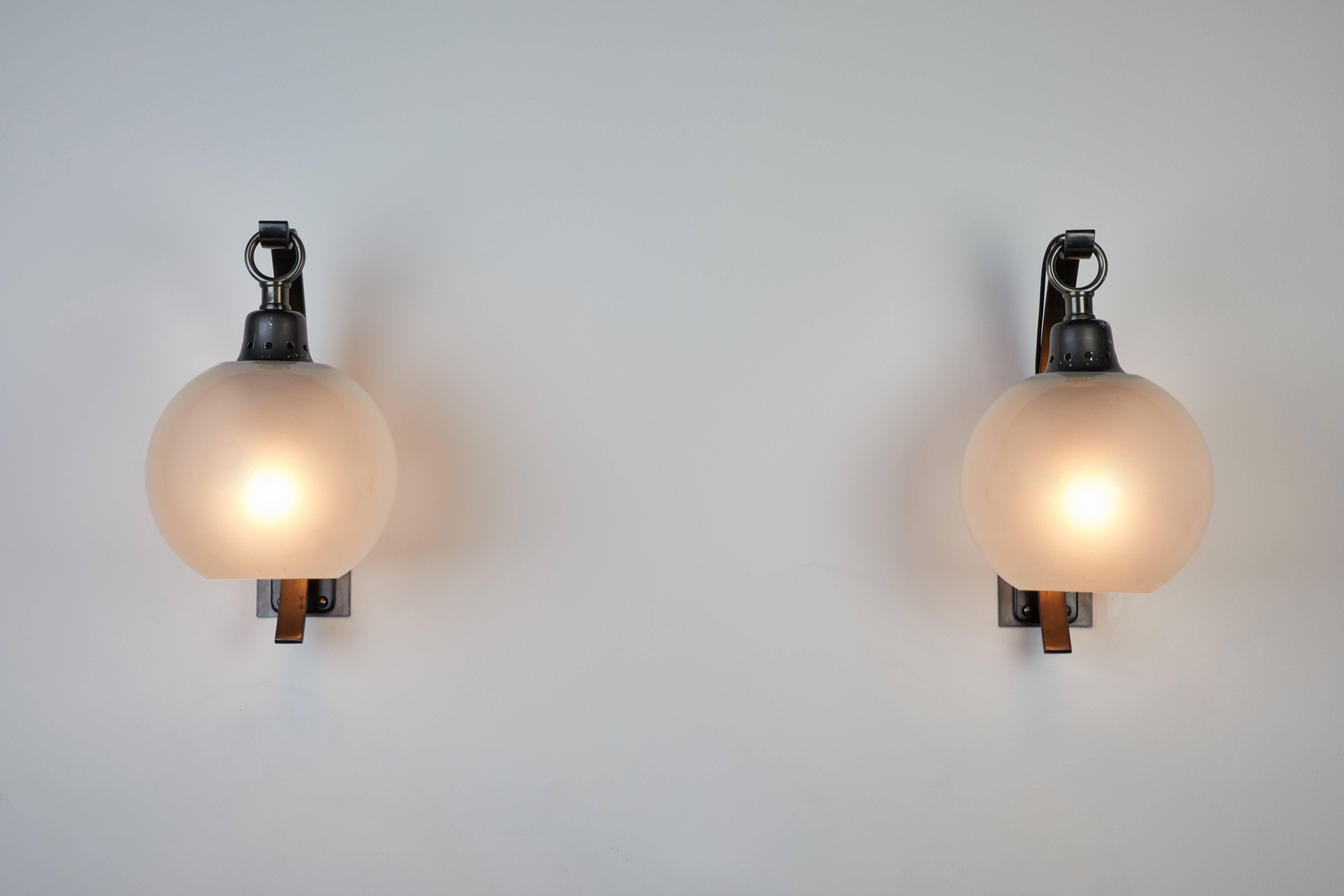 Pair of original Boccia Wall lights designed by Luigi Caccia Dominioni for Azucena in Italy, circa 1980s. Curved arm in steel, socket element in aluminium, hook in burnished iron. Globe in frosted satin glass. Wired for US junction boxes. Each globe