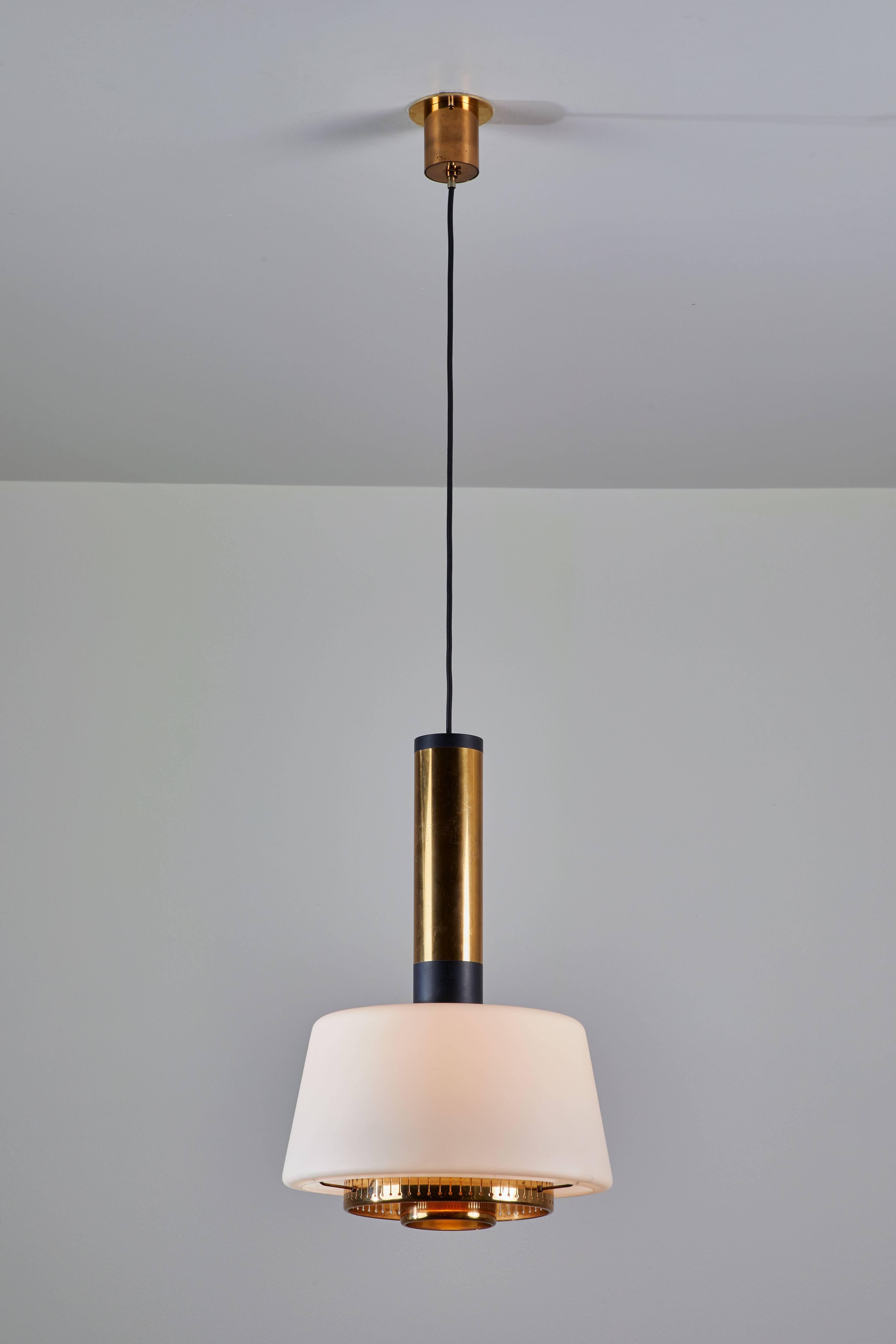 Two pendants manufactured by Stilnovo in Italy circa 1960s. Brushed satin glass diffusers, brass stem and hardware, original canopy with custom brass backplates. Rewired for US junction boxes. Overall drop can be adjusted. Height displayed is for