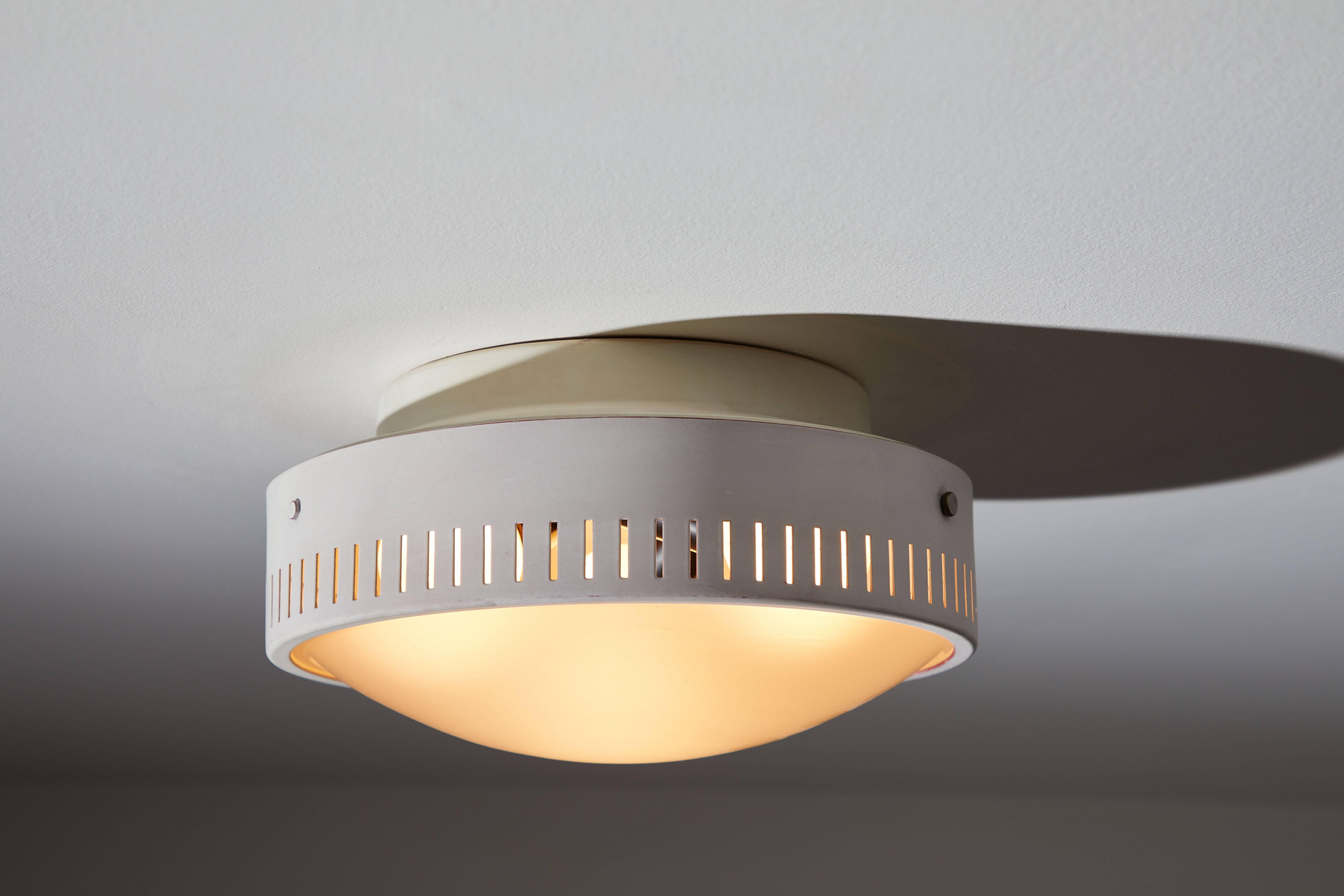 Flush mount ceiling light manufactured by Stilnovo in, Italy, circa 1950s. Enameled, perforated metal. Matte glass diffuser. Retains a part of the original manufacturer's label. Rewired for US junction boxes. Takes three E14 75w maximum bulbs.