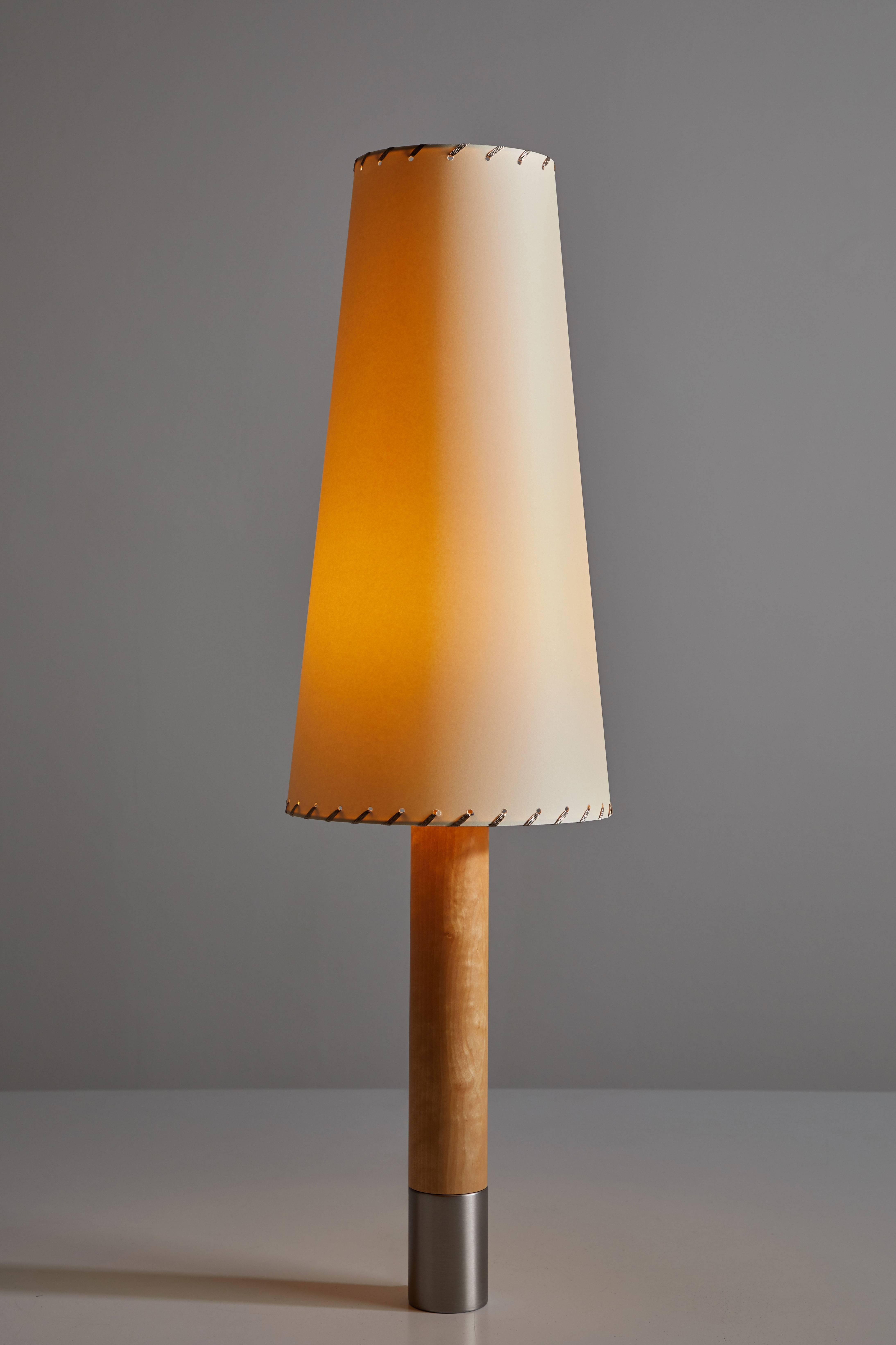 Básica table lamp by Santiago Roqueta for Santa & Cole originally designed in 1987. The current re-edition is wired for the US. A wooden column, held up by a heavy metal base with the same diameter, supports a range of shades in different shapes and
