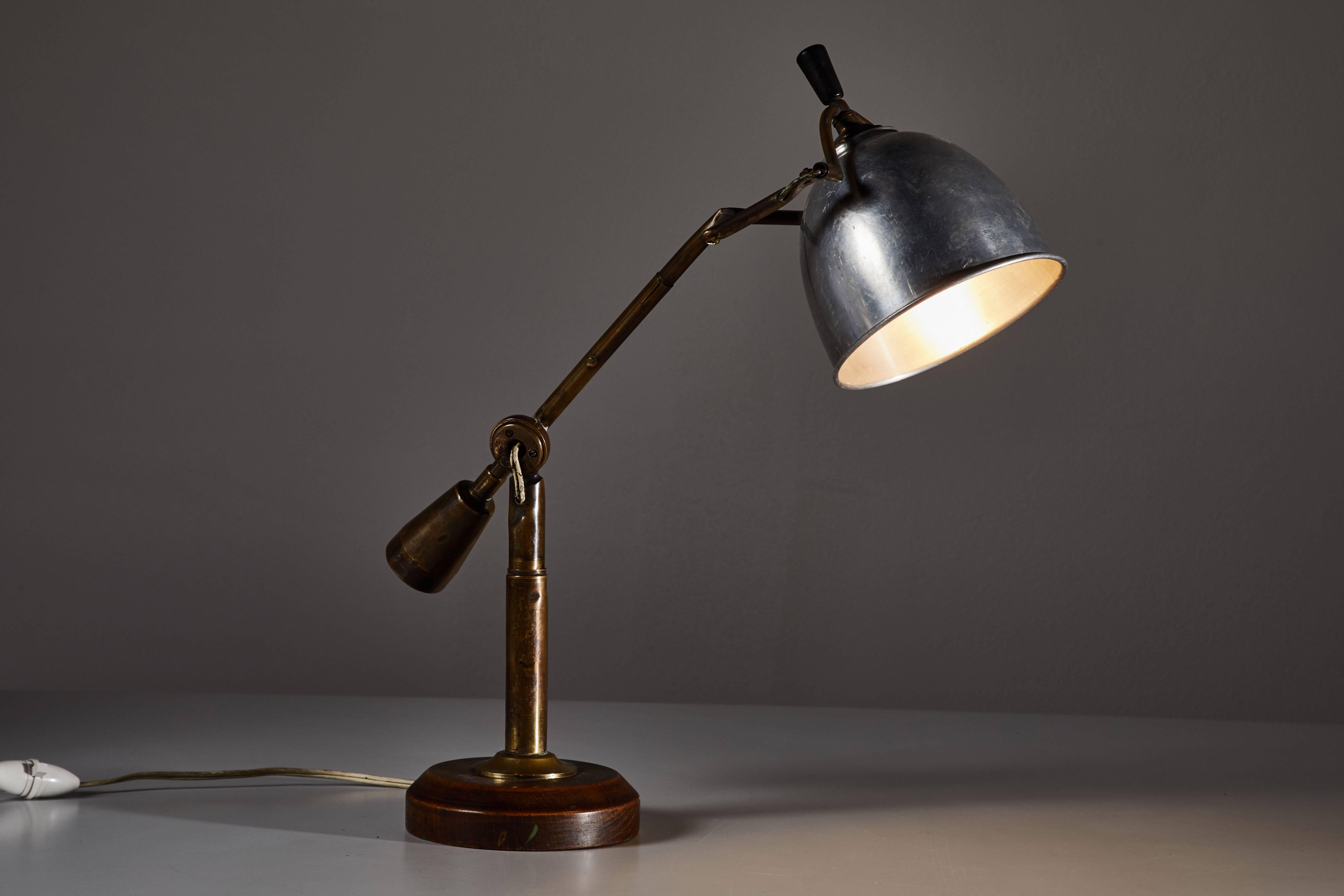 Iconic Table Lamp by Edouard - Wilfred Buquet designed in France circa 1930's. Articulates in several directions with adjustable counterweight. Aluminum shade and nickel plated brass hardware with wooden base. Retains original signed applied metal