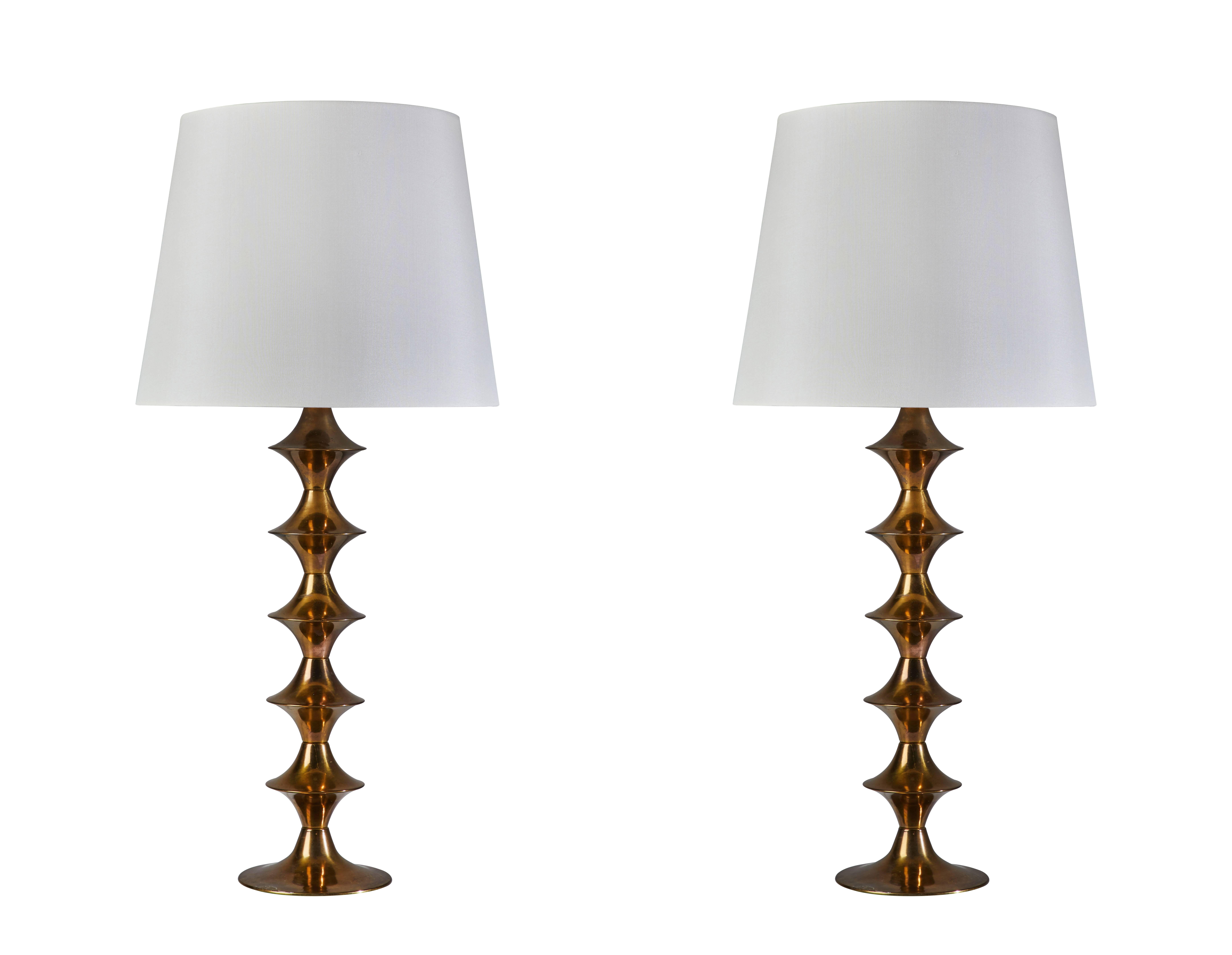 Pair of brass table lamps by Hans Agne Jakobsson designed and manufactured in Sweden circa 1950s. Patinated brass stems with custom fabricated silk shades. Original cords. Each light takes one E27 75w maximum bulb. Shade is 13 inches H x 16 inches D