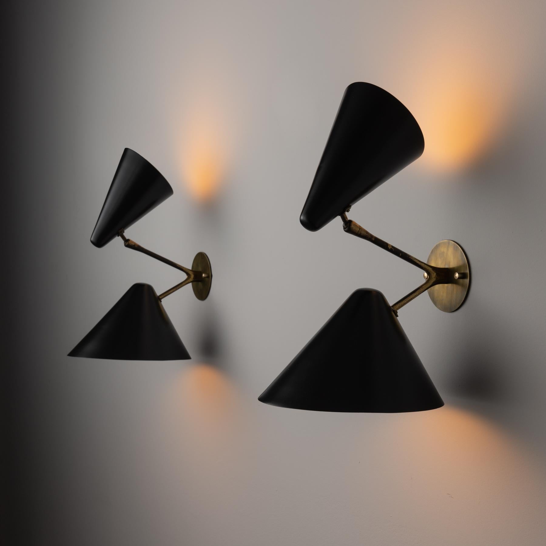 Pair of double shade sconces by BAG Turgi. Designed and manufactured in Switzerland, Circa 1950'S. Brass, enameled metal. Custom brass backplate. Shades adjust to various positions. We recommend two E27 60w maximum bulbs per sconce. Bulbs not