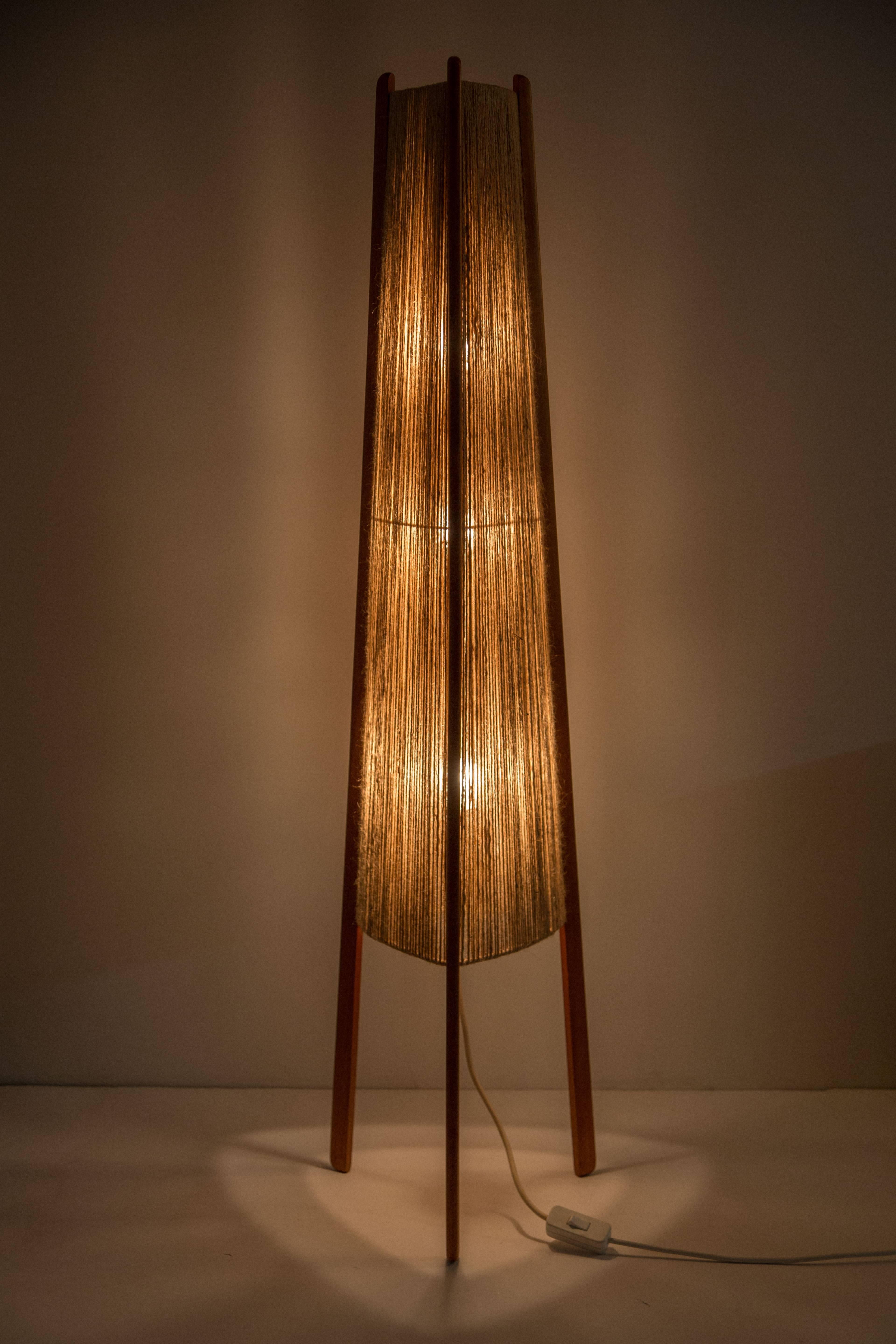 A handwoven jute shade with solid teak legs.