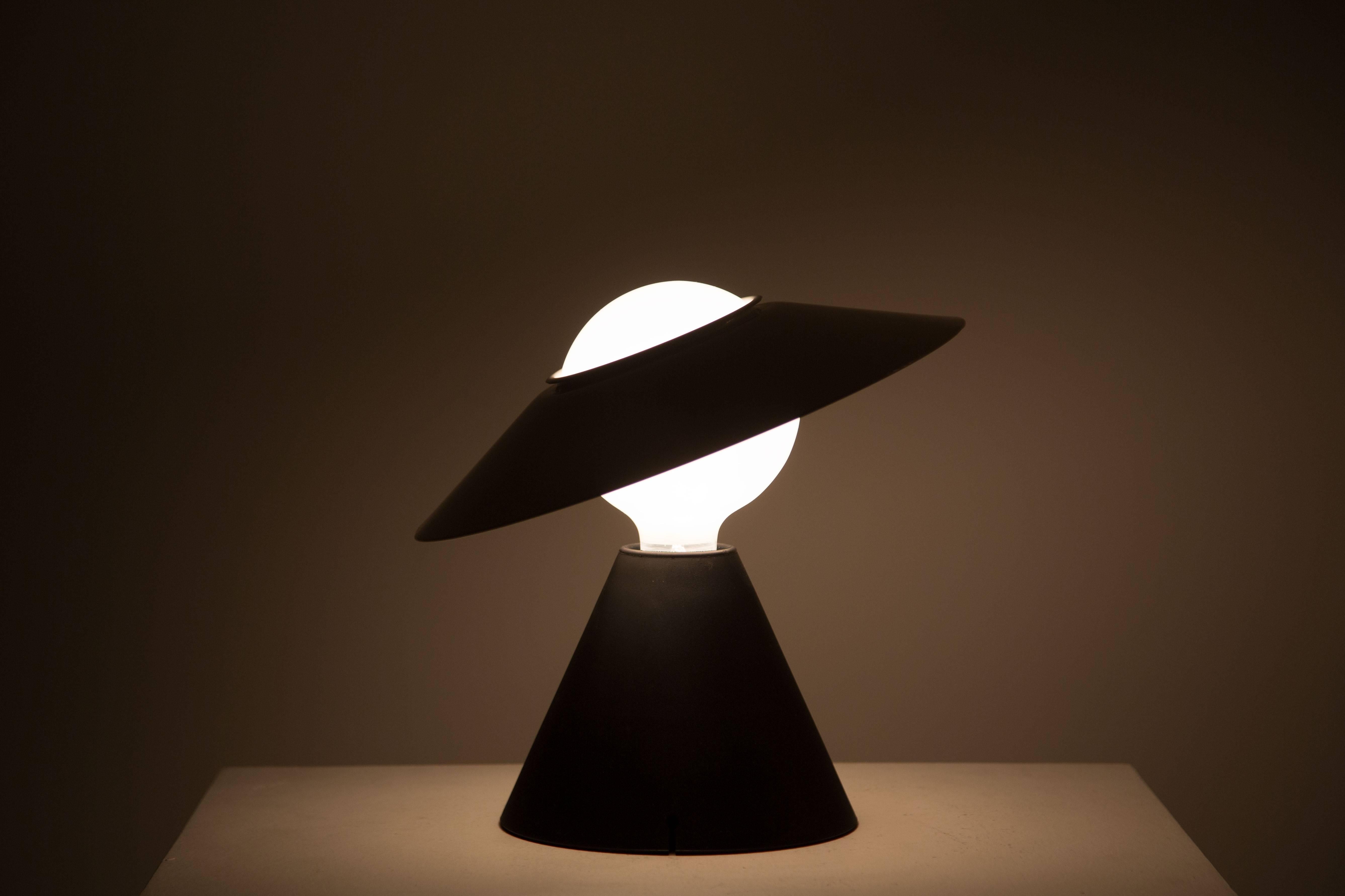 Iconic metal, rubber and white glass table lamp. Comes in original box.