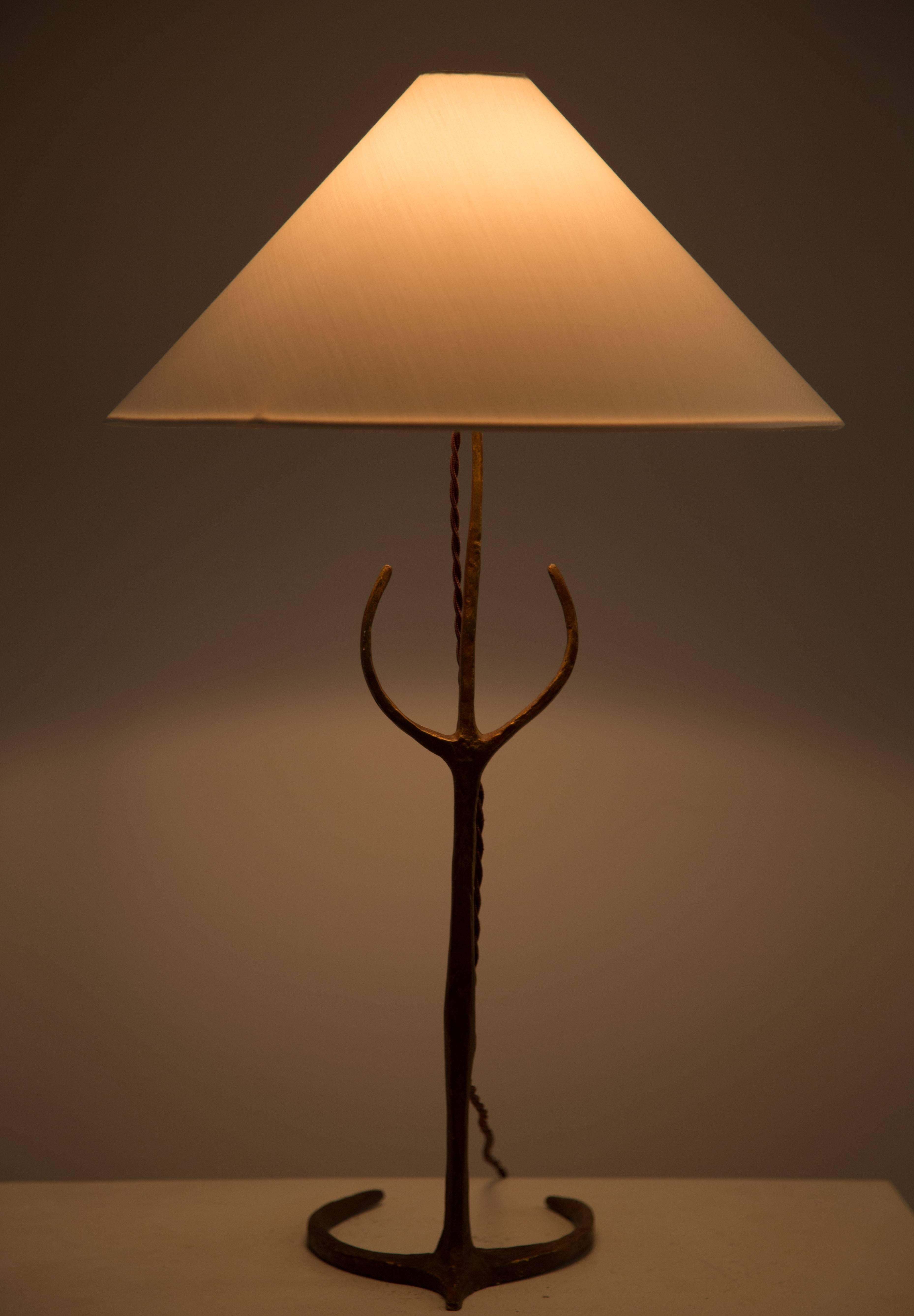 A sculpted bronze table lamp with a new silk shade.
    