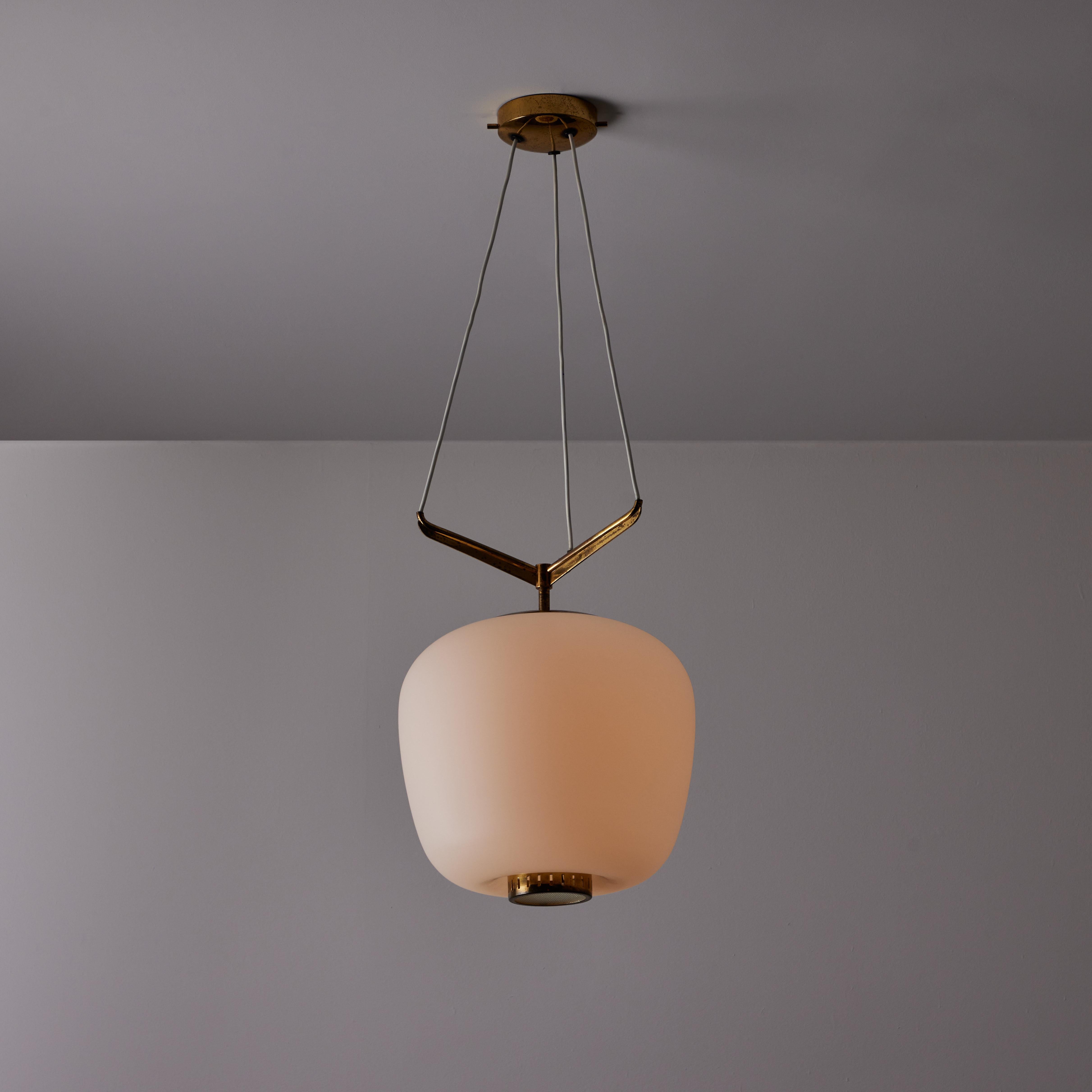 Lampada a sospensione di Stilnovo. Prodotto in Italia, intorno agli anni '50. Presenta un grande paralume in vetro smerigliato e tre armature di sospensione in ottone. Il diffusore in vetro bombato inferiore aggiunge un bel dettaglio a questo