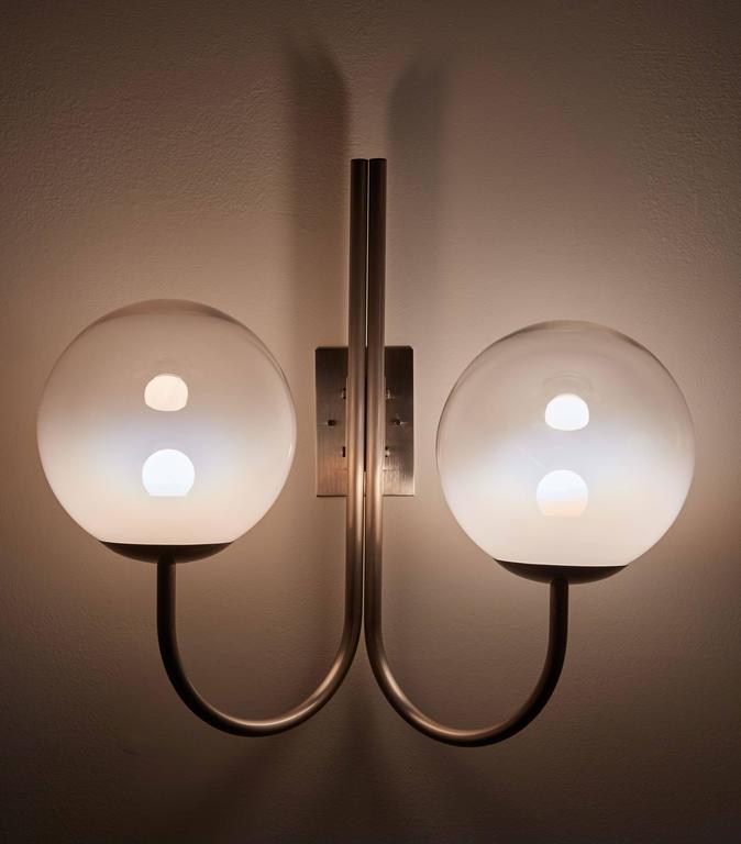 Four glass wall lights. Each light has two opaline globes, brushed aluminium with custom nickel-plated brass backplates. Wired for US junction boxes. Each globe takes one E27 75w maximum bulb.