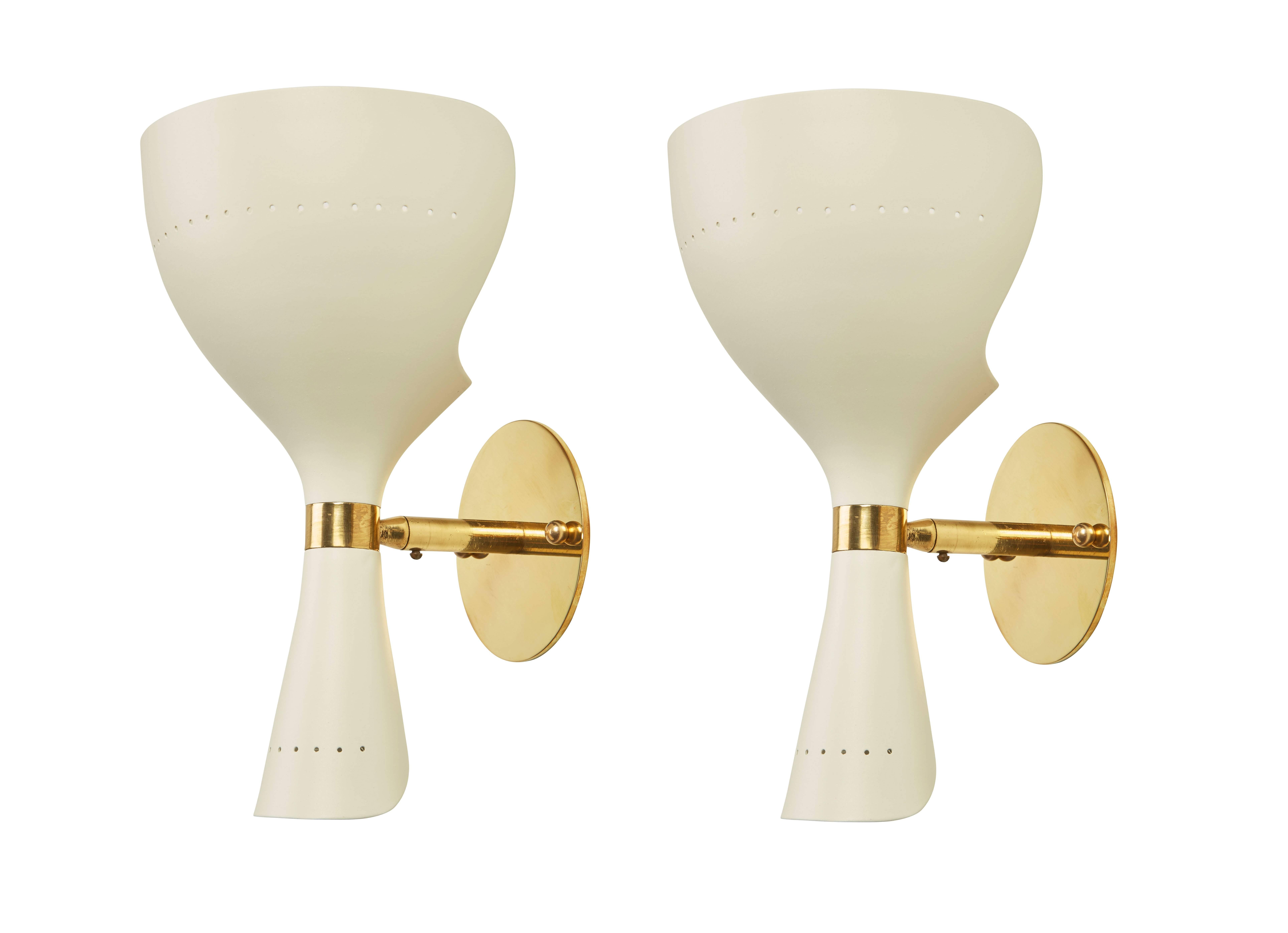 Pair of enameled metal and brass sconces manufactured in Italy by Stilnovo, circa 1950s. Sconces can be mounted in either direction with the small part of the shade on the bottom, or the small part of the shade at the top. Perforation to top and