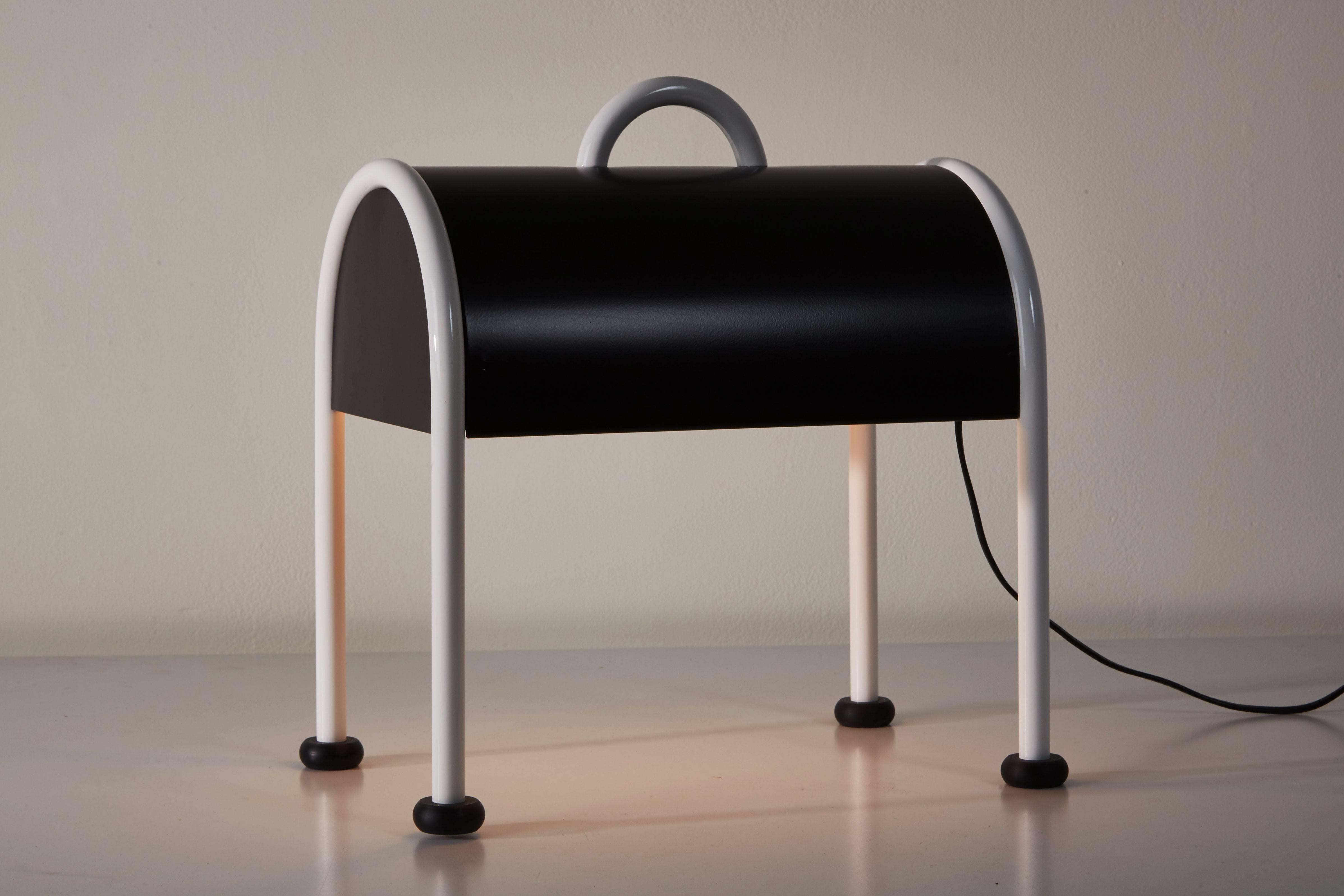 'Valigia' desk lamp by Ettore Sotsass for Stilnovo designed in Italy in 1977. Inspired by the idea of a simple bent plate, with details in painted metal. The Valigia remains an icon in the vast repertory of design by Ettore Sottsass. Black metal