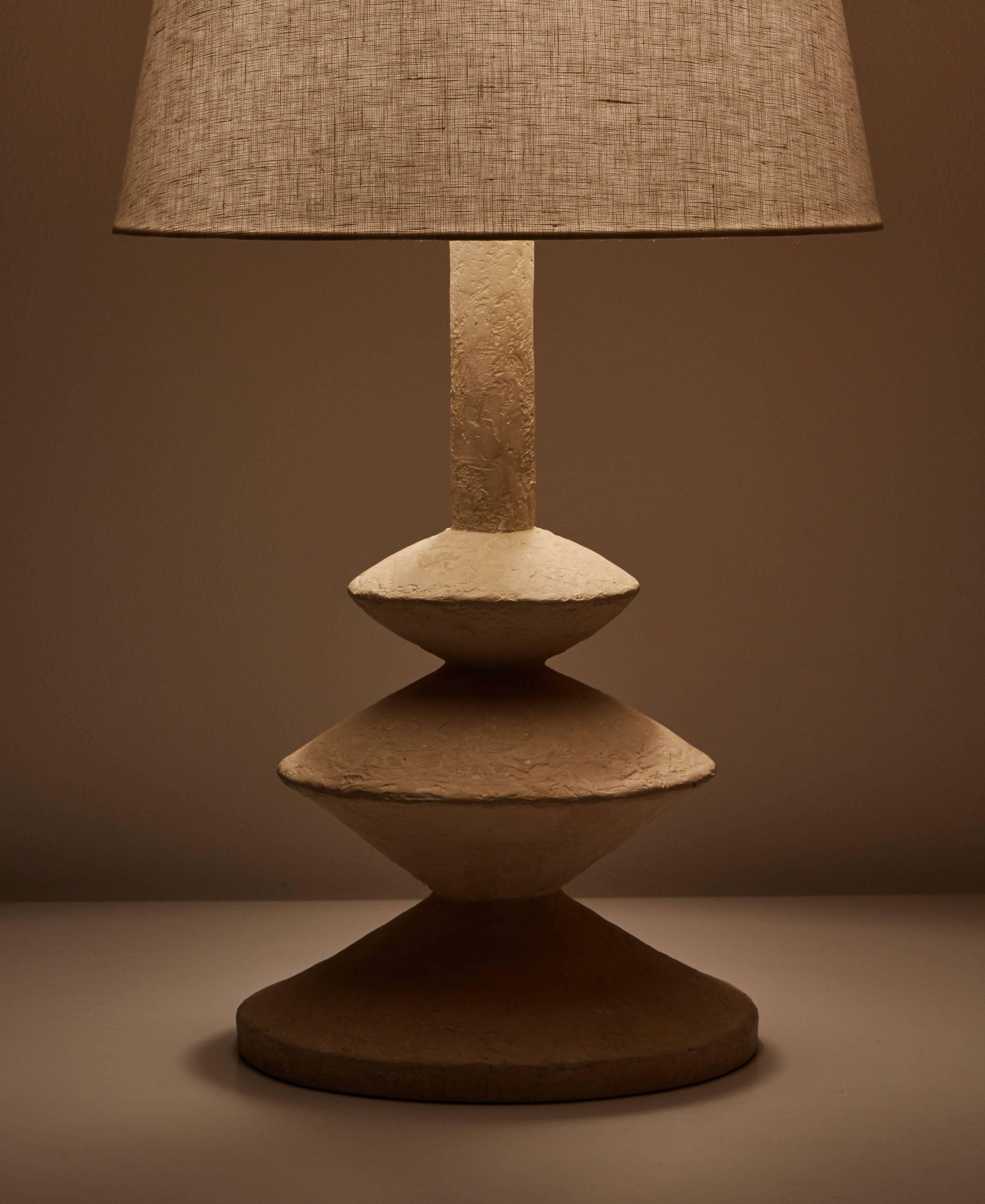 After Giacometti solid plaster table lamp, 1970s. Original cord. Takes one E26 100w maximum bulb. Shade not included. Custom shade fabrication available.