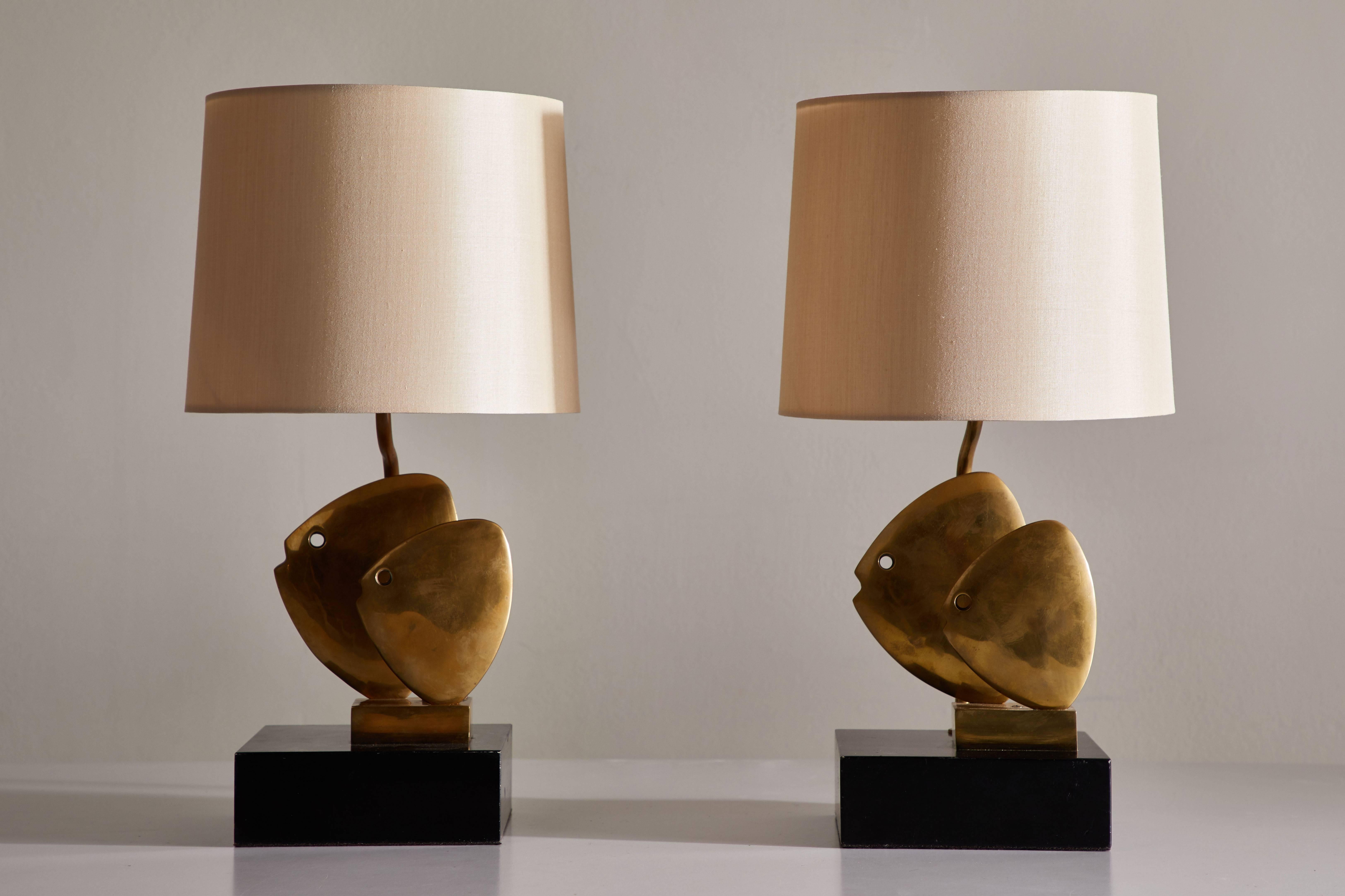 Pair of solid cast brass table lamps. Designed in France, circa 1970s. Solid cast brass-mounted to lacquered wood base. Custom silk shades included. Rewired with black French twist silk cord. Each light takes one E26 75w maximum bulb.