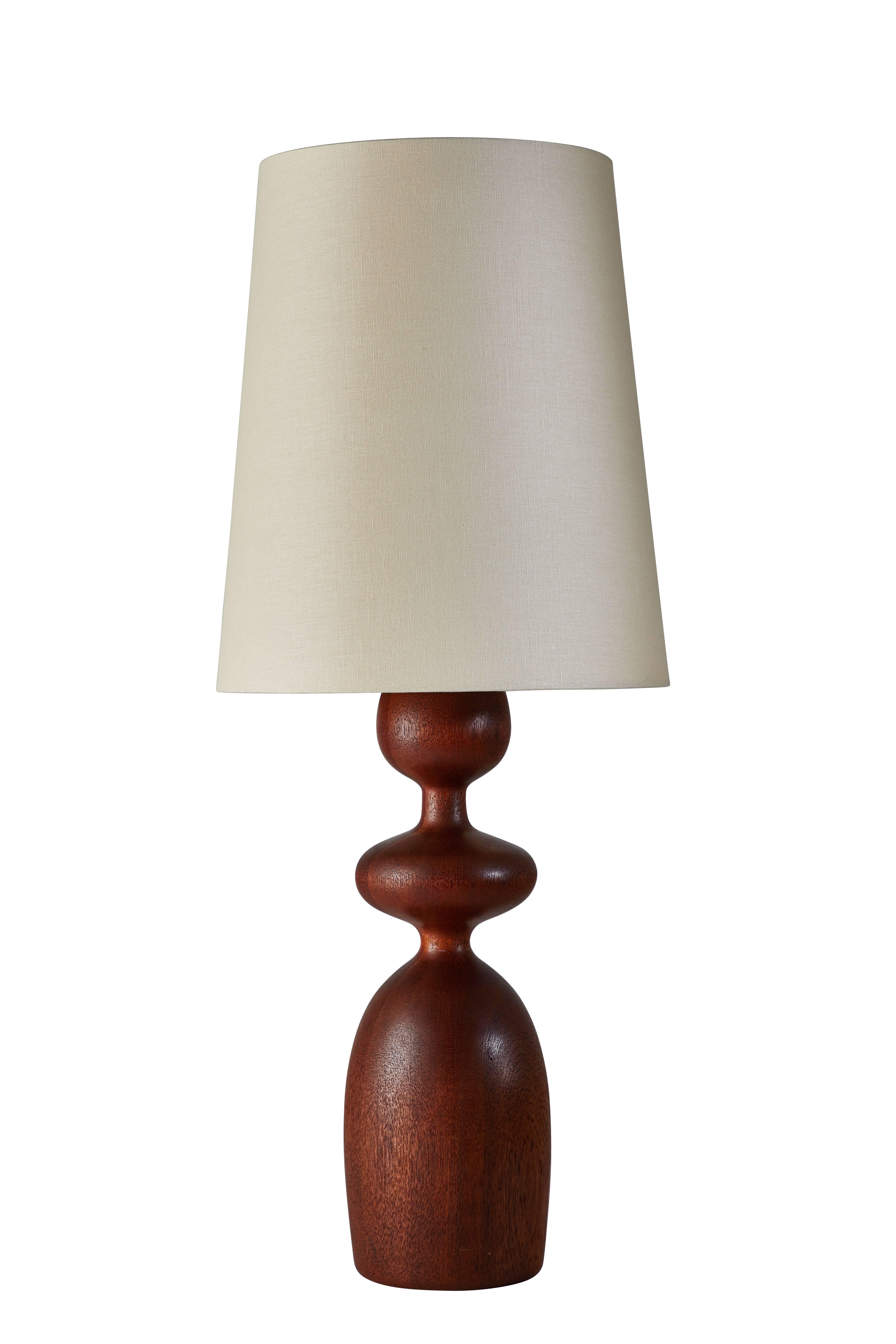 Sculpted teak Danish table lamp manufactured in Denmark circa 1960. Includes custom linen shade. Original cord. Shade measure 15 inches in height, 10 inches in diameter. Takes one E-27 75w maximum bulb
