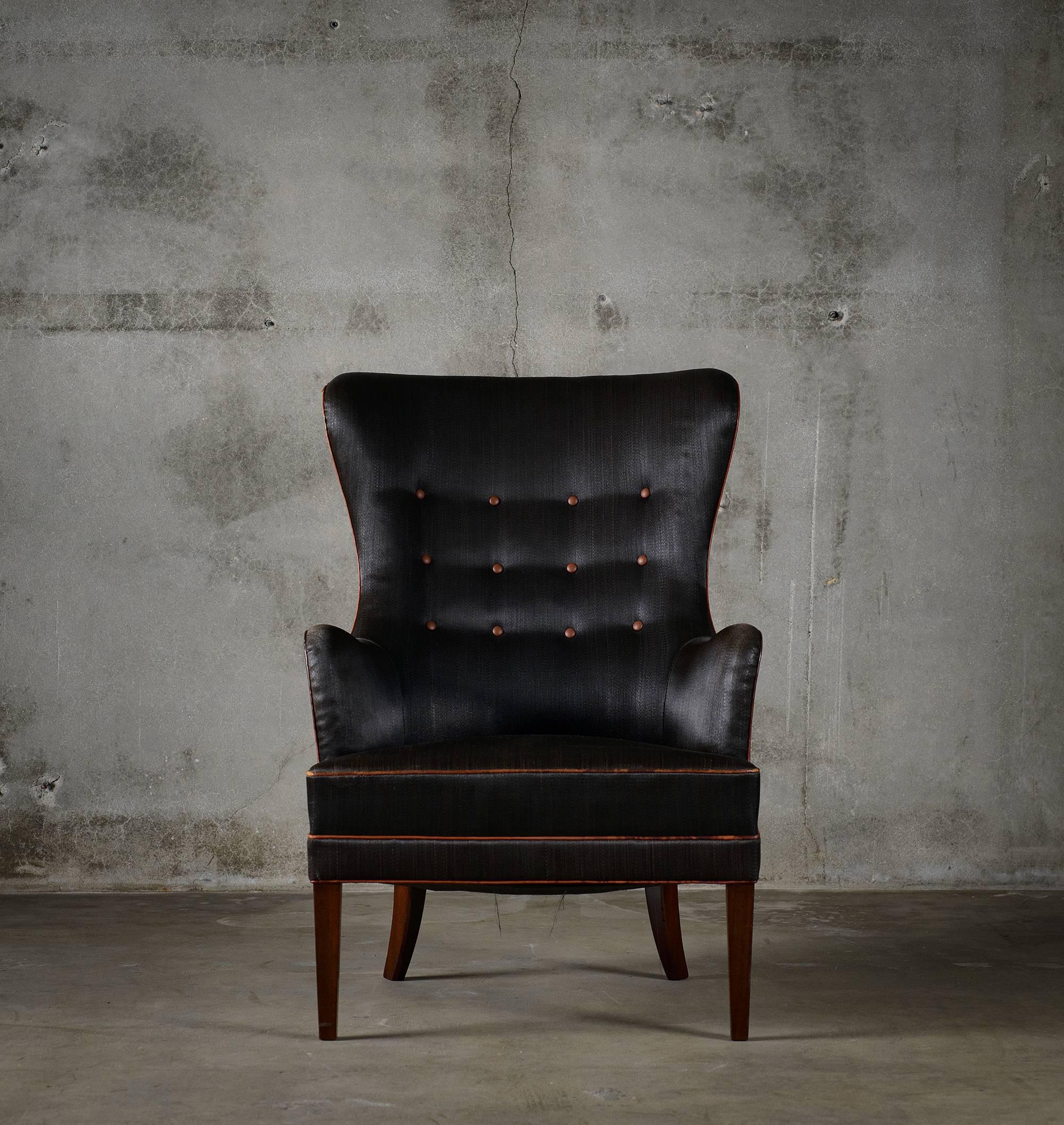 Frits Henningsen high back easy chair with mahogany legs, upholstered in black horse hair with red leather trim.