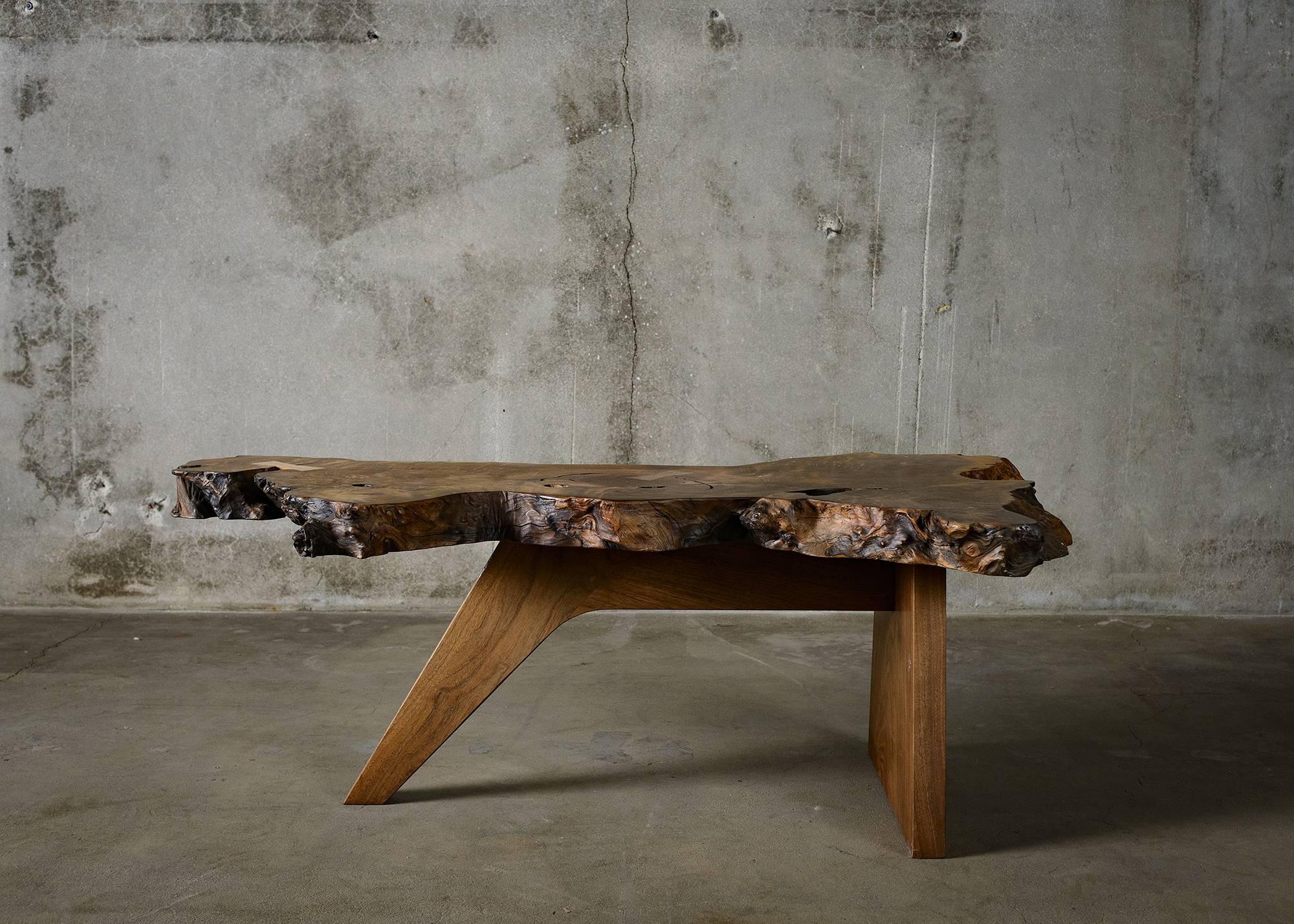 A masterfully crafted Mira Nakashima table from burl wood, the rounded knotty growth on a tree.
 