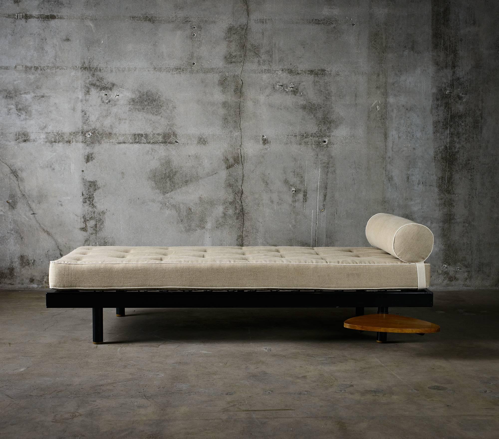 Black lacquered metal frame daybed with wooden swiveling pad and upholstered in fabric. The swiveling pad designed by Charlotte Perriand, circa 1950s.