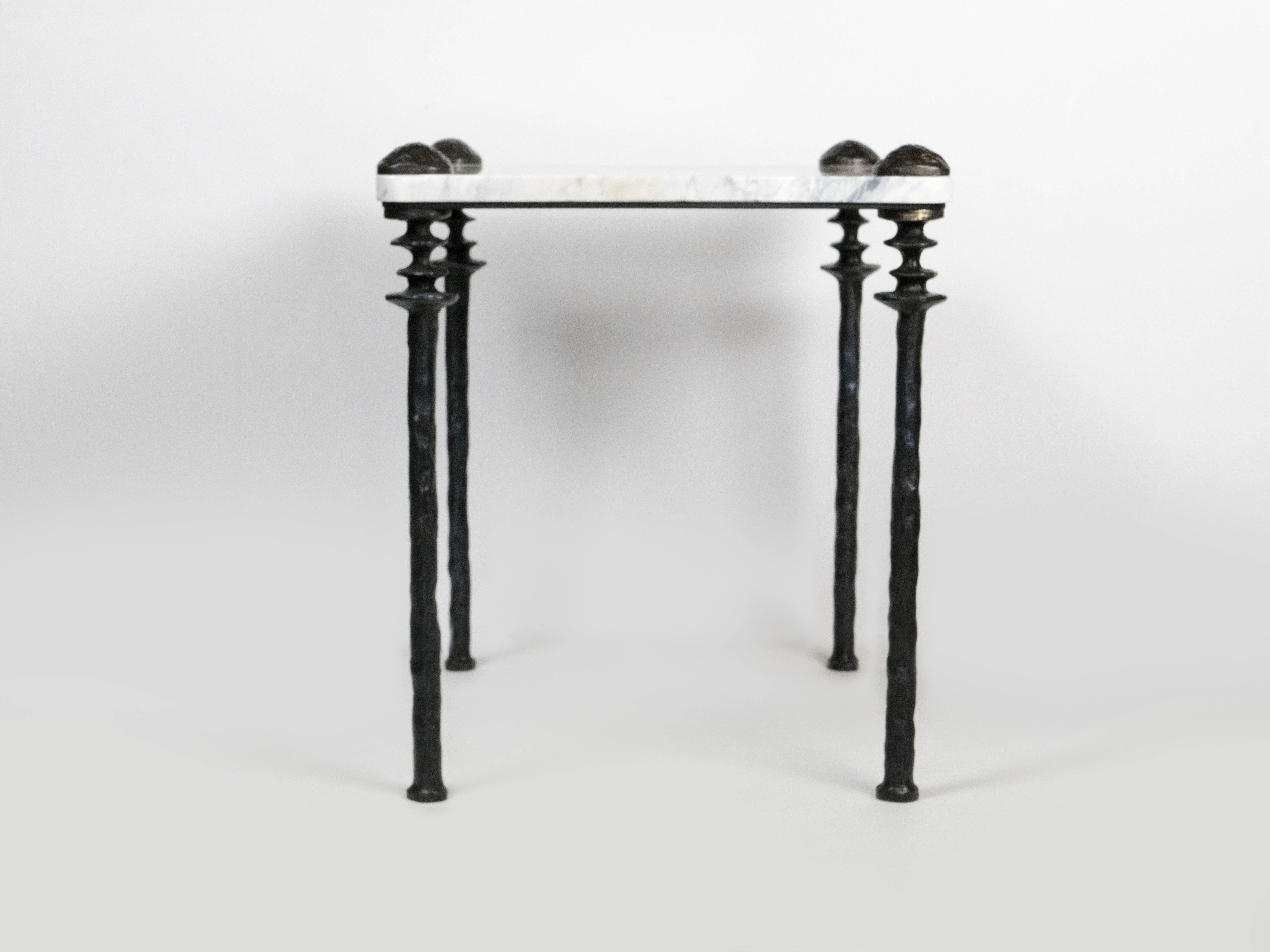 Two marble-topped small scaled side tables. The legs are cast bronze.  Unique organic texture of the bronze legs.  Three heights of legs are available.  Can be created with or without the decorative elements on the top of the marble.  
 