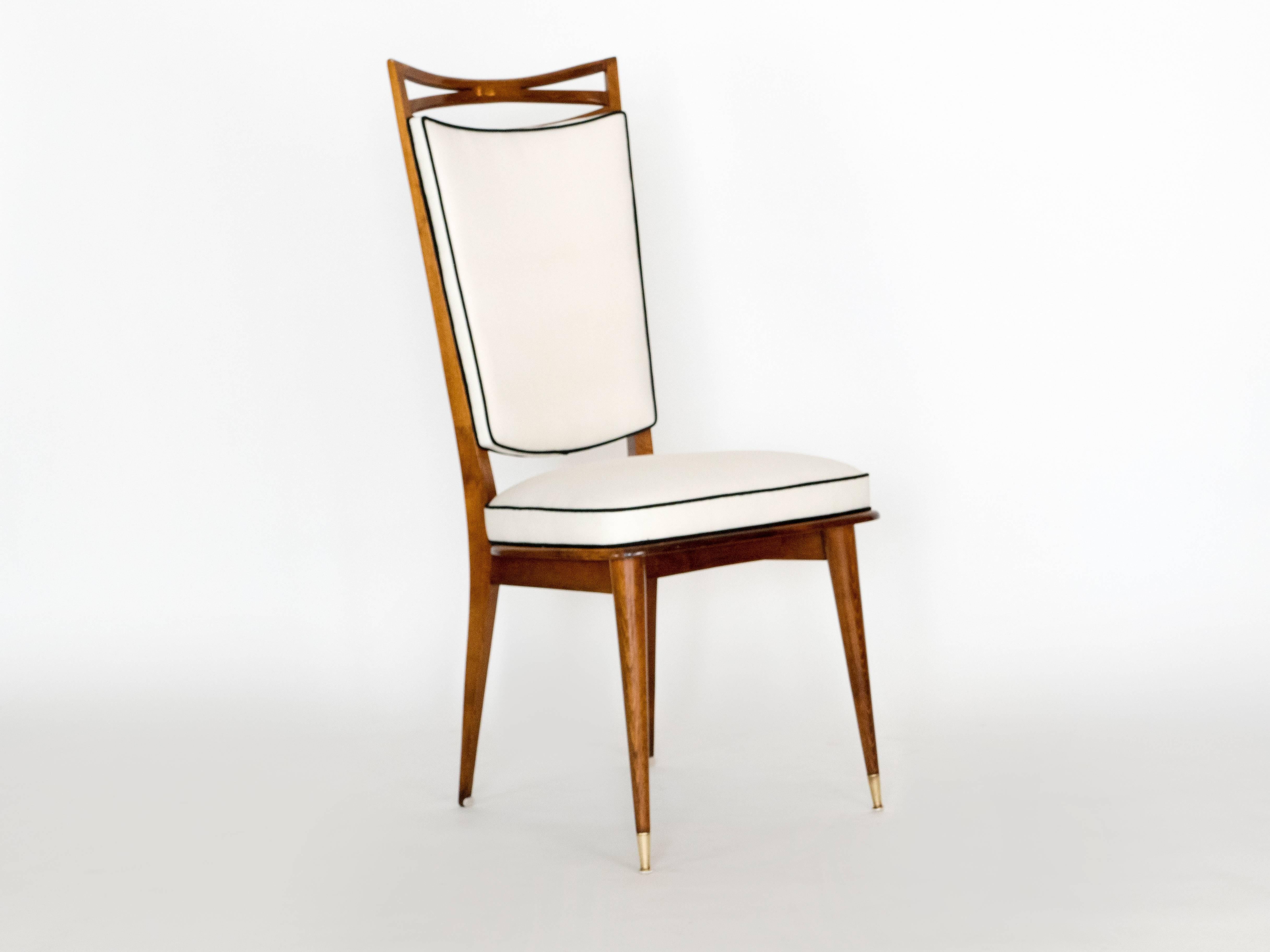 These six chairs are very design. The well crafted wood frames and brass detailing make for a lovely set of dining chairs. The frames have been solidified and covered with a white denim fabric with black welting. Marked with a stamp for a French