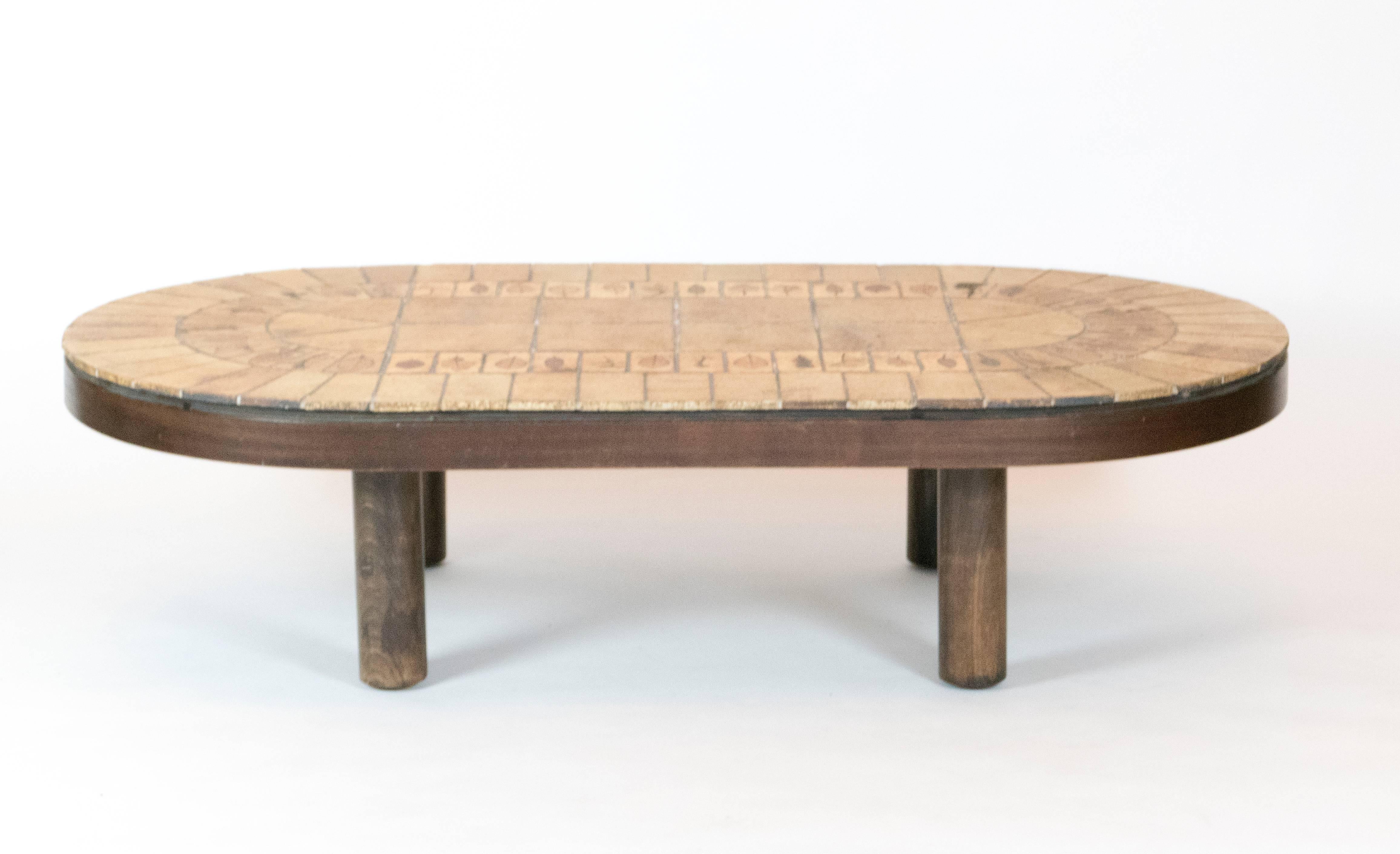 Mid-Century ceramic tiled topped coffee table. This signed table by R. Capron has a walnut frame. The tiles have leafed imprint design of his Herbier style.