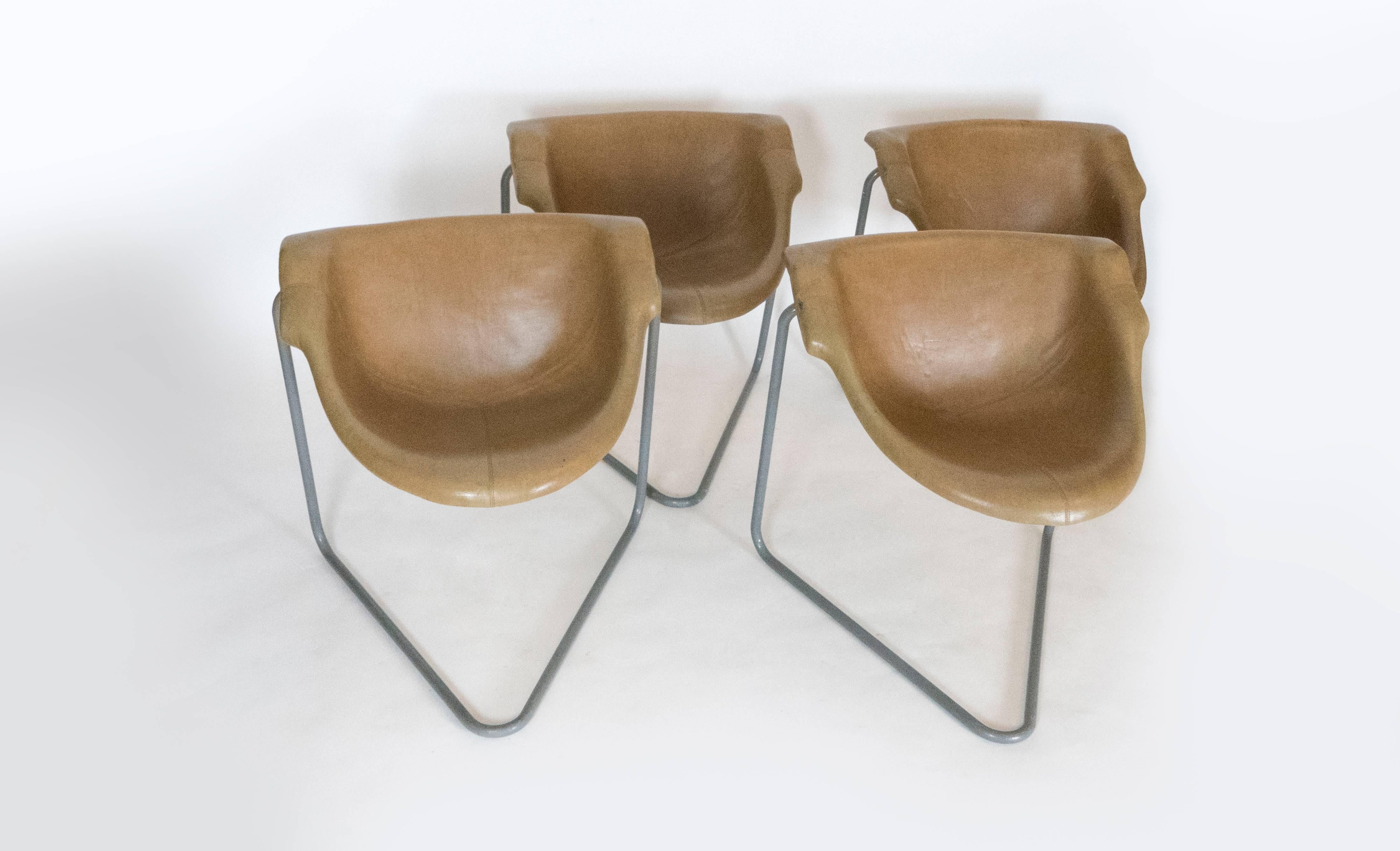 These four chairs designed by Kwok Hoi Chan were manufactured by Steiner. The cantilevered design of the legs and the molded plastic seat provide for a comfortable seat. The chairs have a beautiful aged patina and stitched details.   Items are in