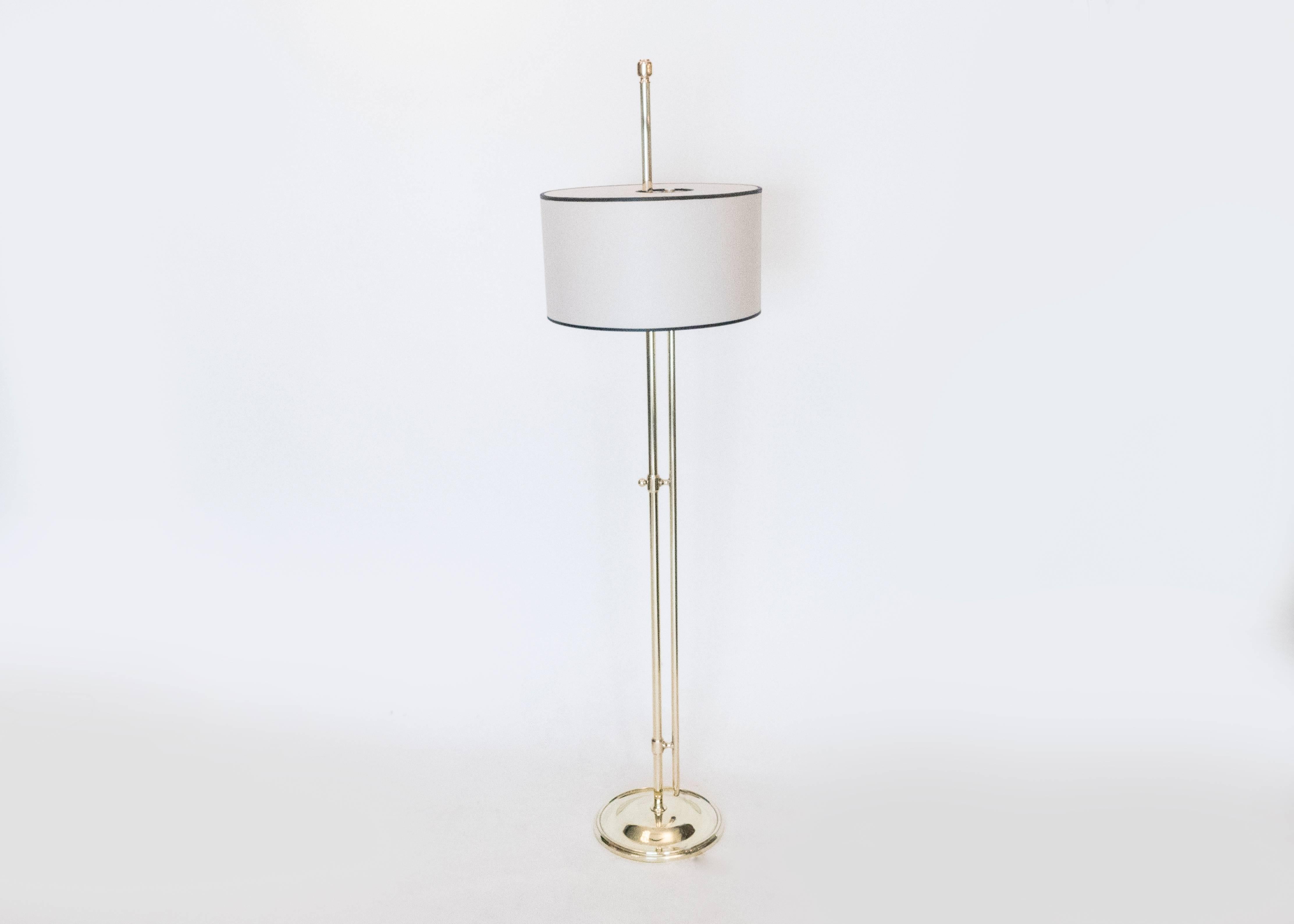 A beautiful pair of floor lamps in brass. Their unique design allows for them to adjust their height while the frame passes through the parchment shade. Maximum height is 65