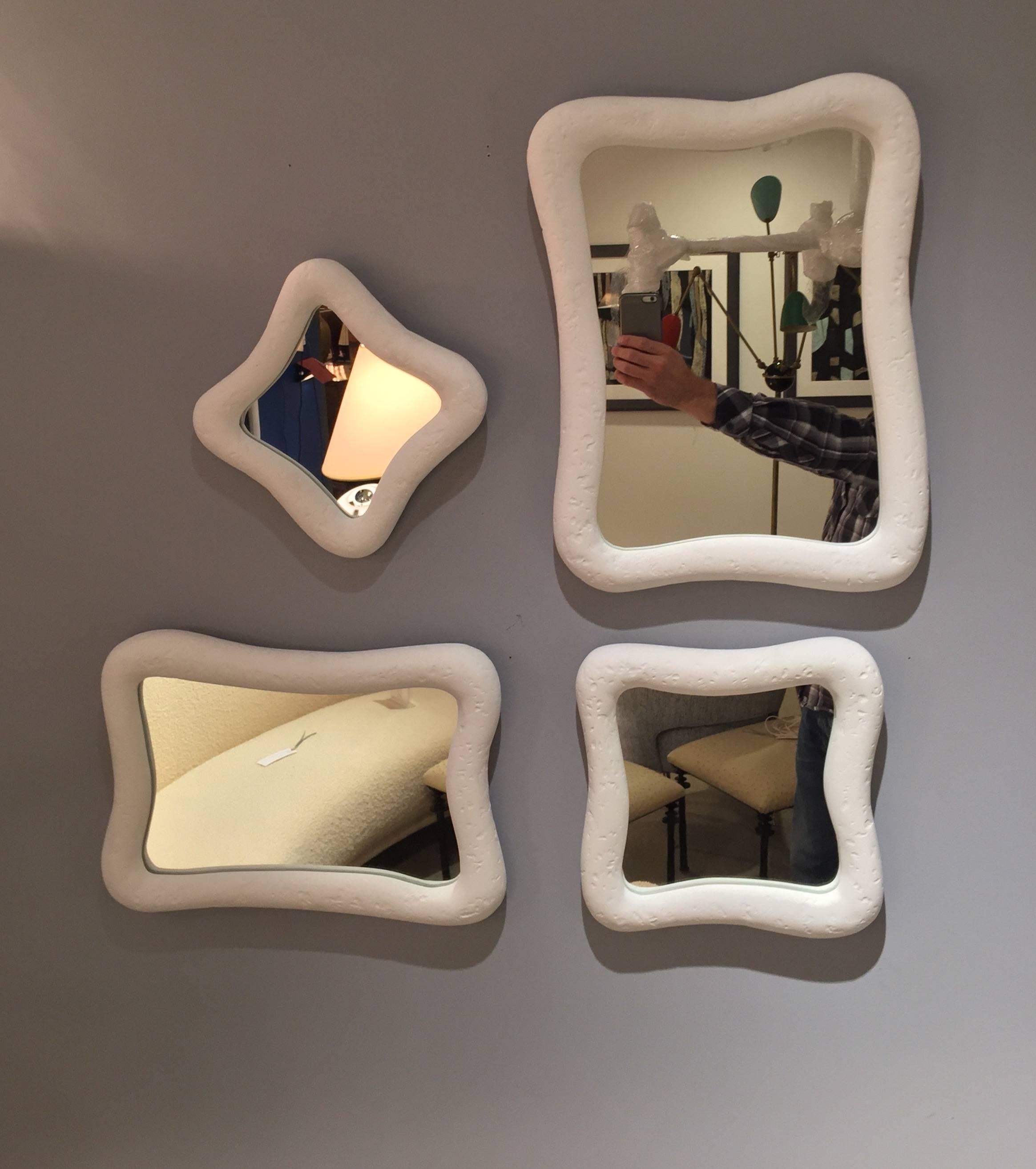 These eight mirrors with these organic shapes are crafted with our signature plaster of Paris finish. The disposition of mirrors can be arranged in various configurations. Mirror dimensions two at 8