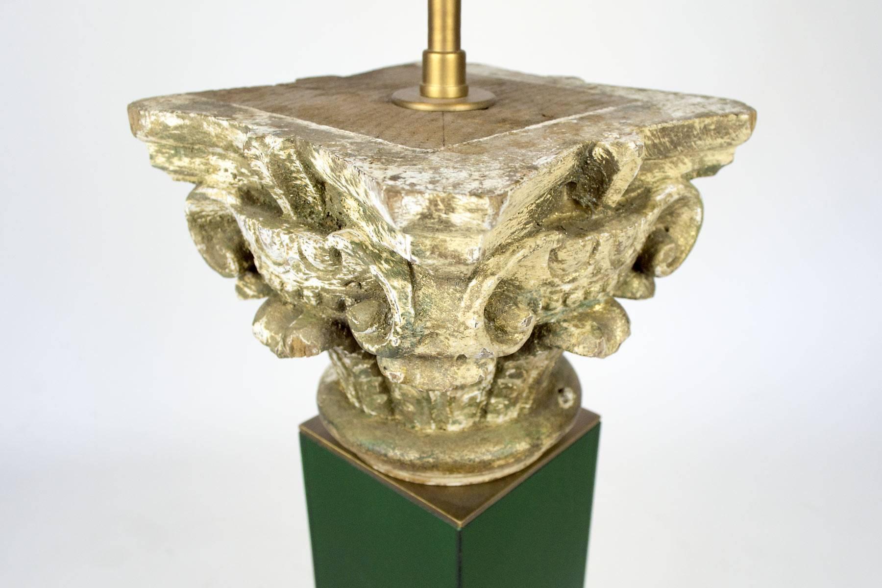 Cette lampe de table a un chapiteau en bois sculpté du 18ème siècle monté sur une base en plexiglas. Abat-jour en lin avec doublure en feuille d'or. La lampe est dans notre salle d'exposition à New York.