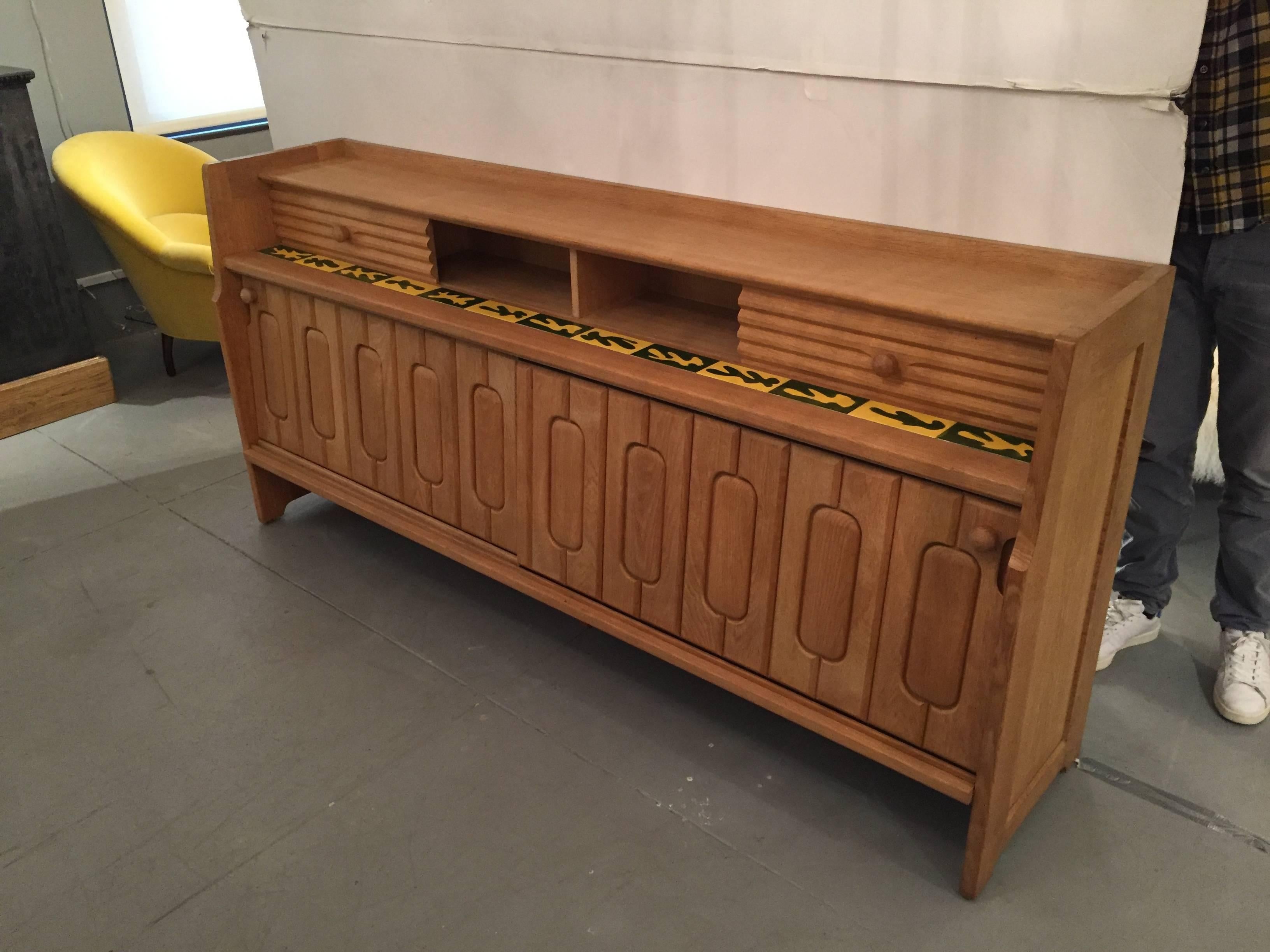 Stately oak buffet designed by Guillerme et Chambron. It has a beautiful ceramic tile design and the details of the workmanship of the wood details is perfection. The rare piece is in perfect condition. It is located in our showroom in NYC in the NY