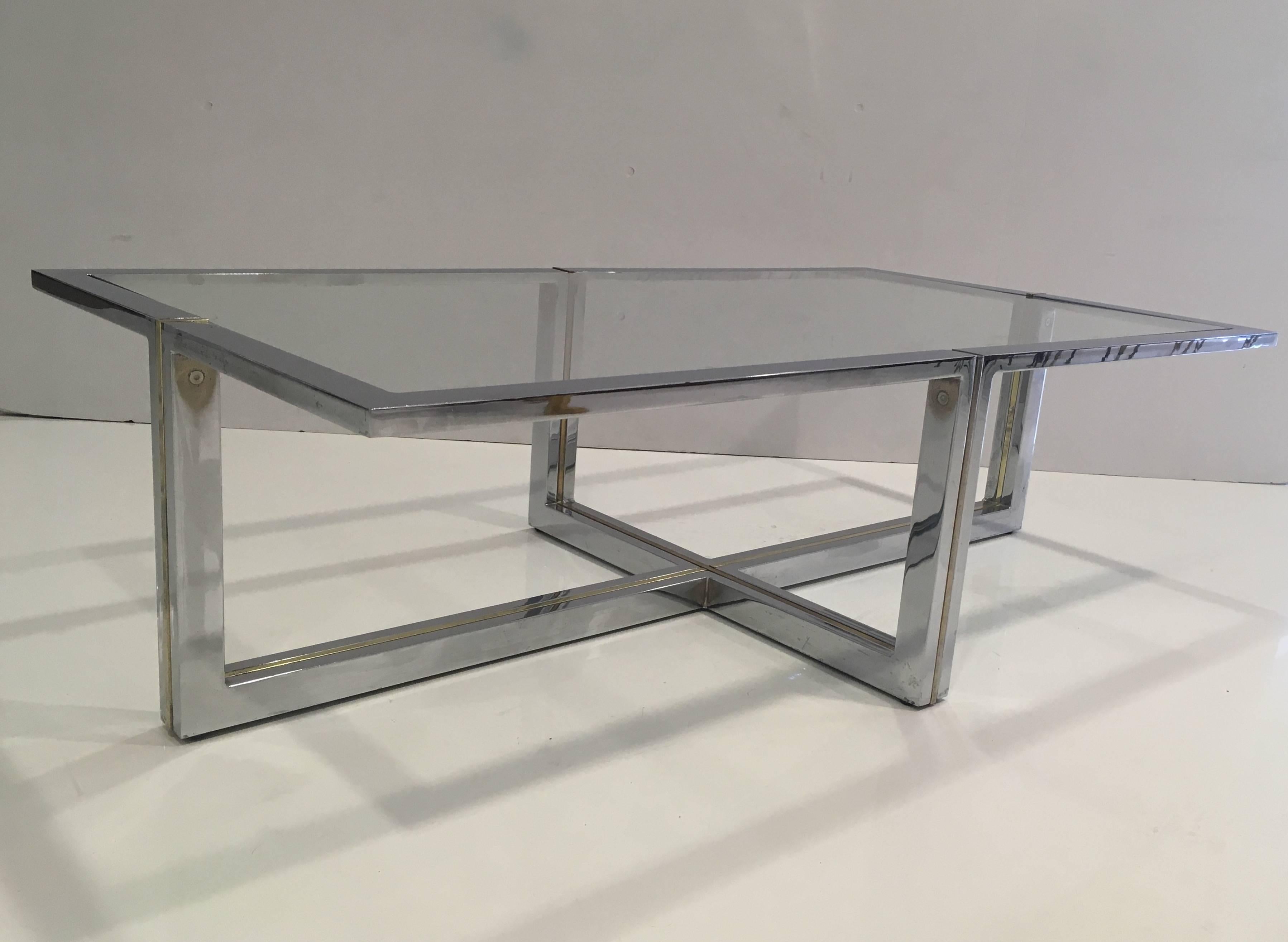 This elegant designed coffee table has a chrome finish with brass detailing inlay. New glass top.