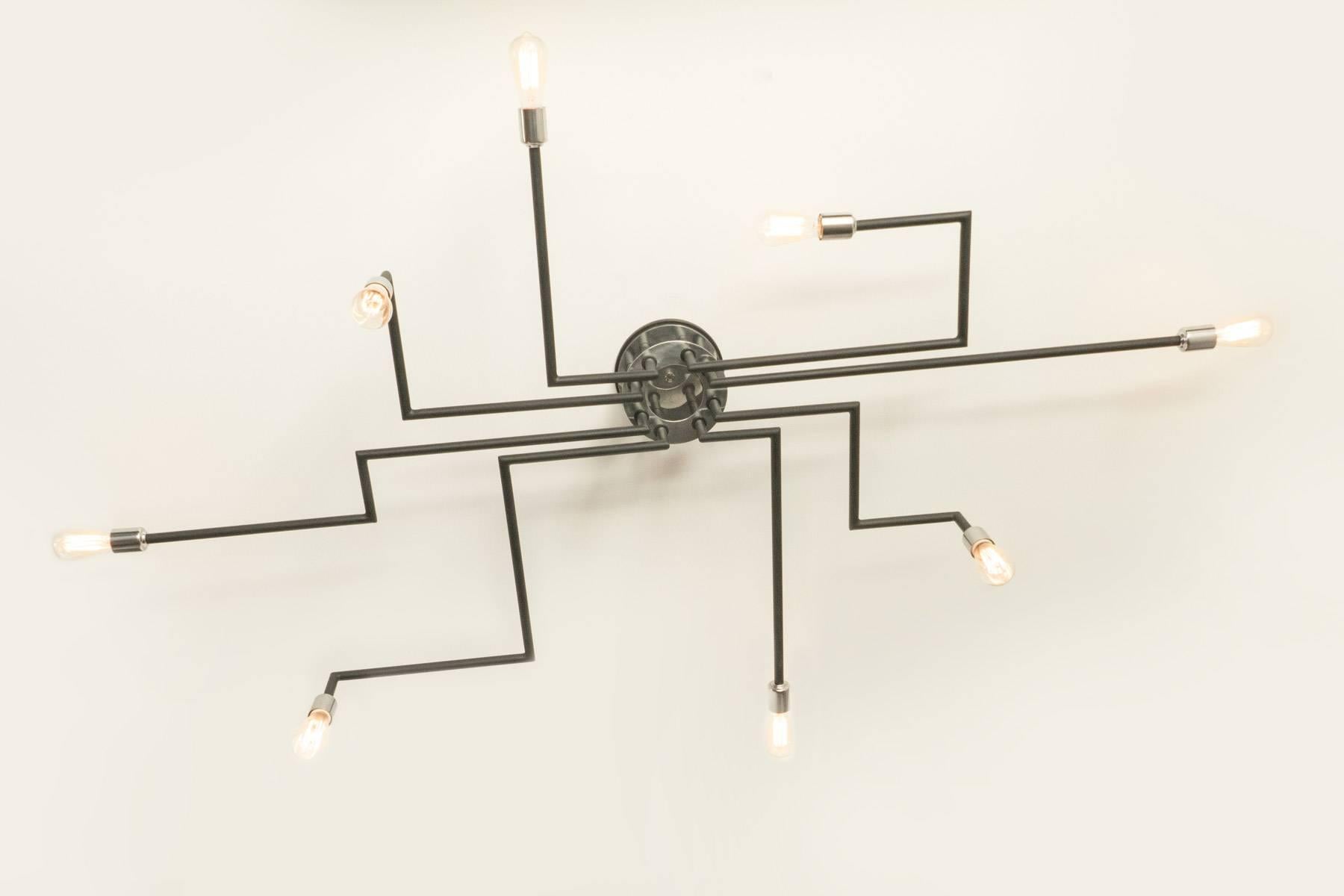 Eight-arm chandelier with Minimalist design. The fixture hugs the ceiling with its eight asymmetrical arms. Black enamel finish with polished aluminum accents. Light uses eight medium based sockets. Max wattage 100 each.